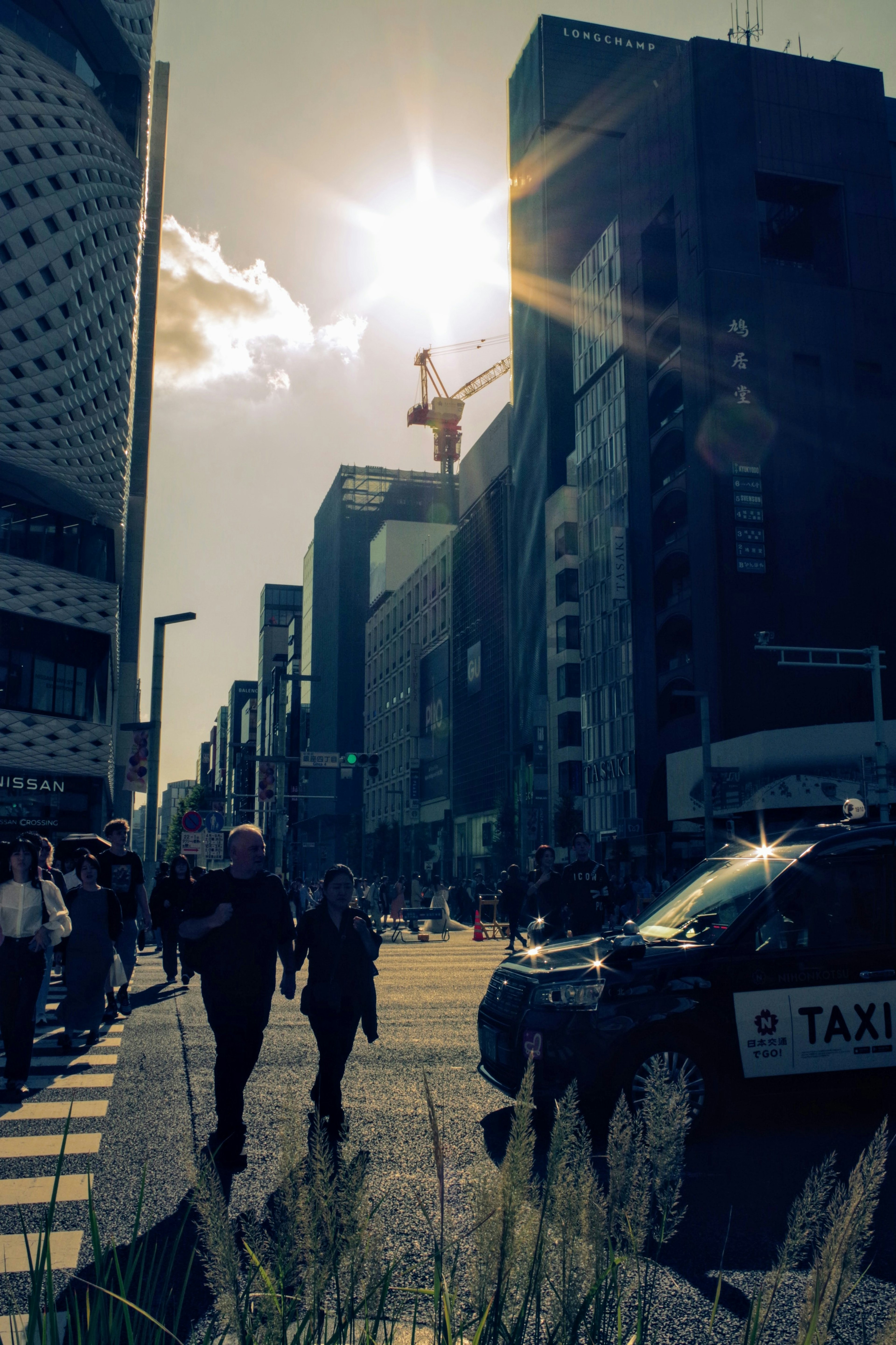 都市の交差点で歩行者とタクシーが見える風景