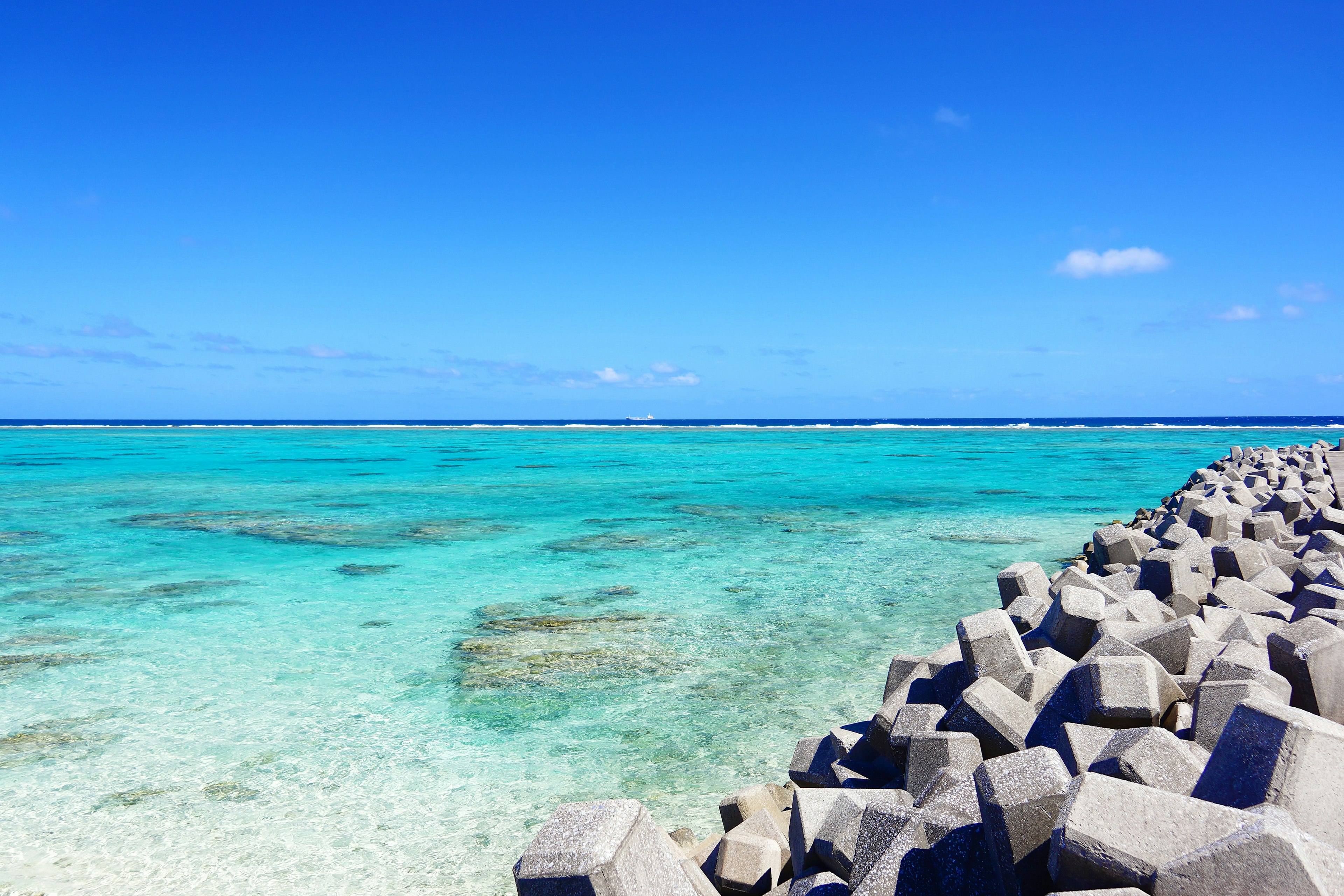 Laut turquoise cerah dengan breakwater beton