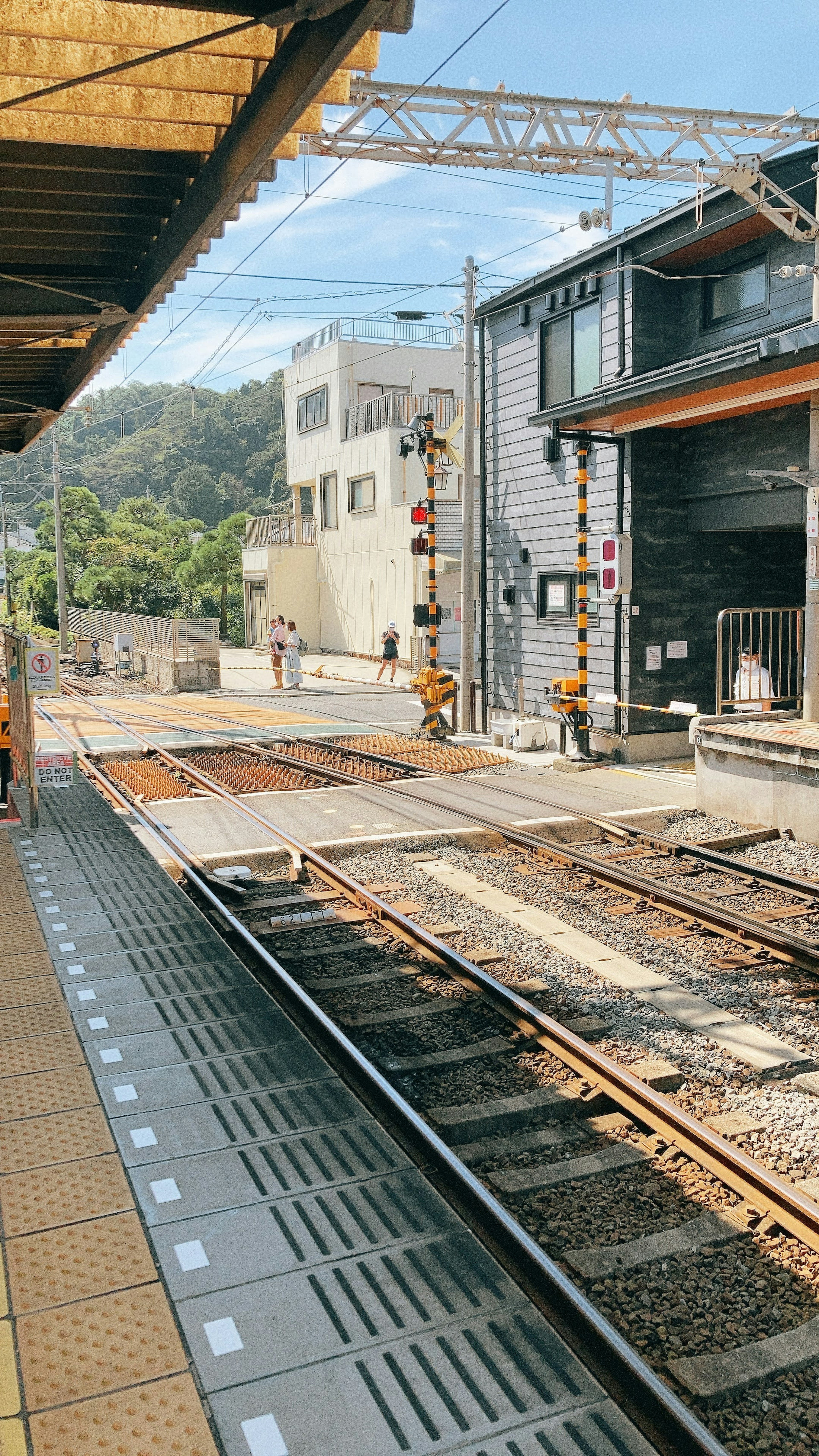 Train station platform with visible tracks and buildings