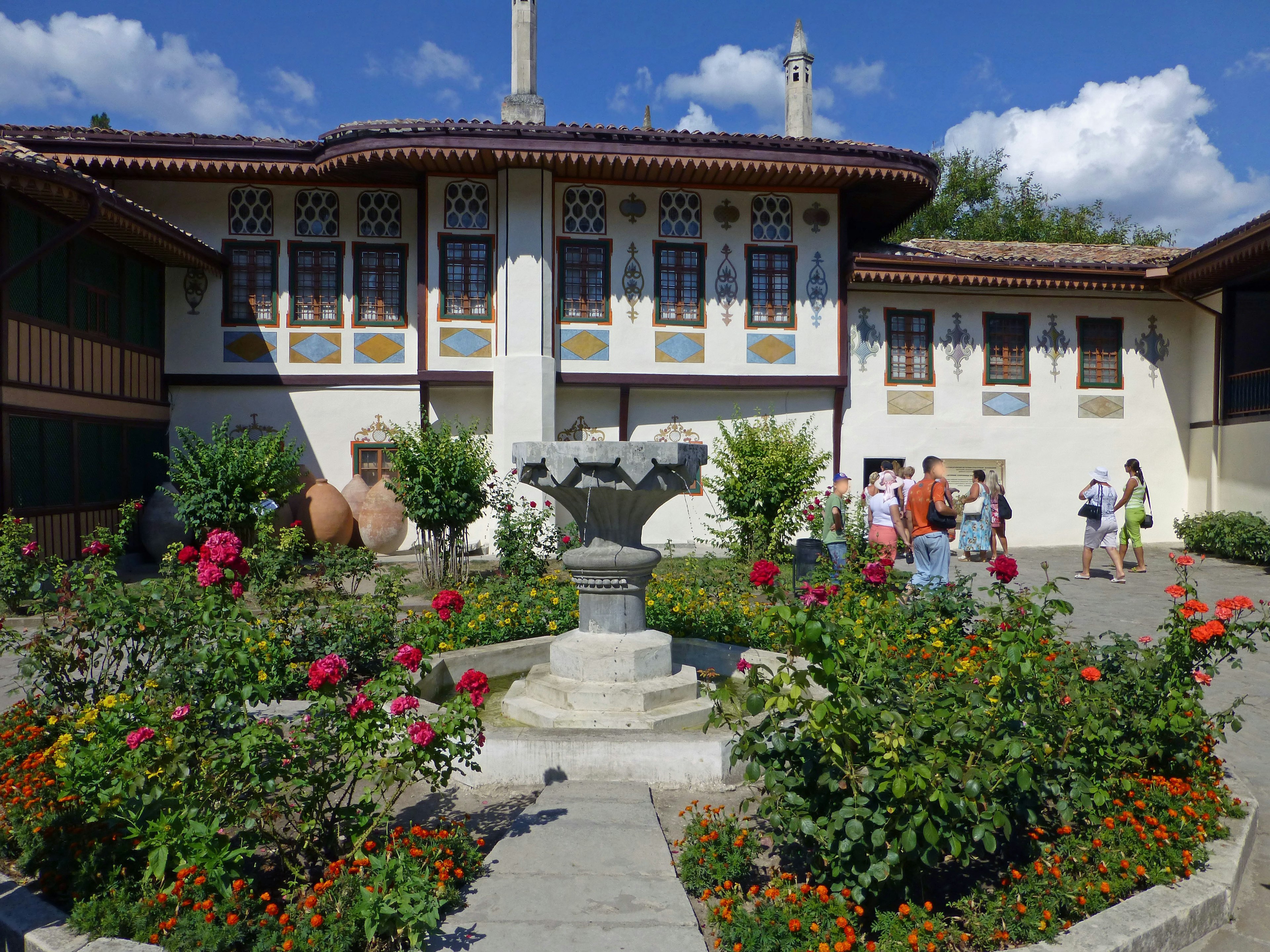 Bâtiment historique avec jardin magnifique et personnes rassemblées