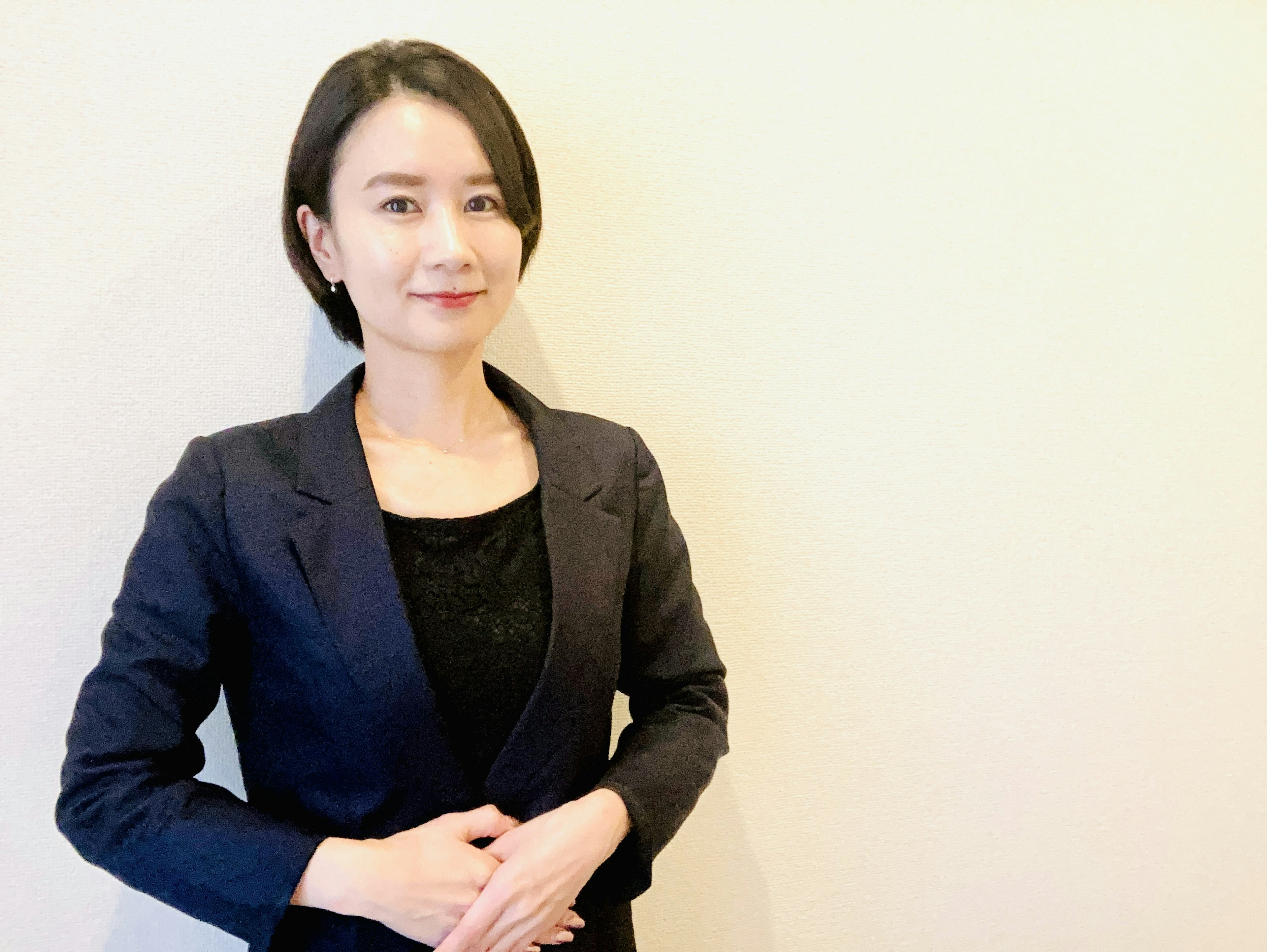 A business-style woman smiling in a professional outfit