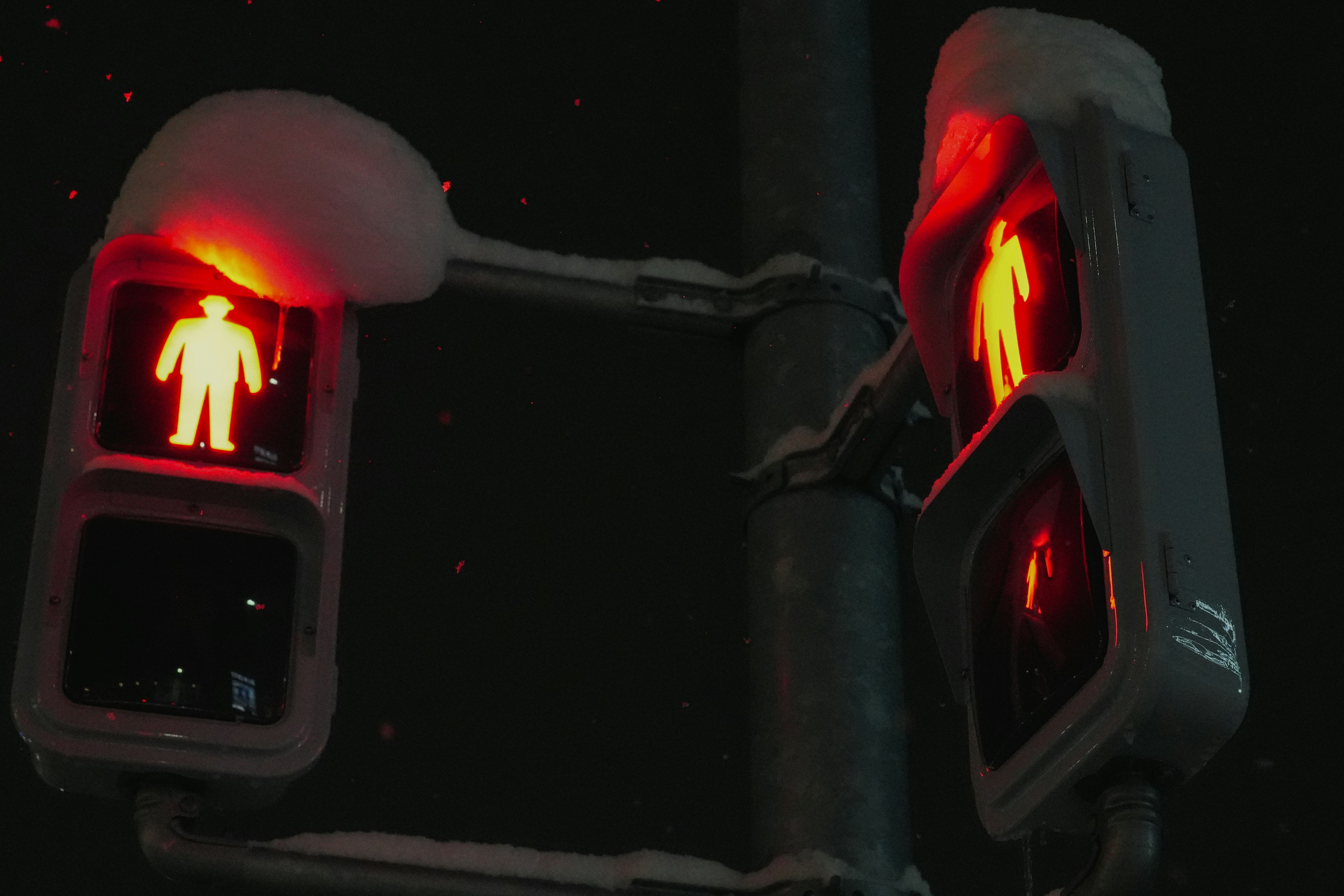 Feux de circulation piéton rouges illuminés la nuit à un carrefour