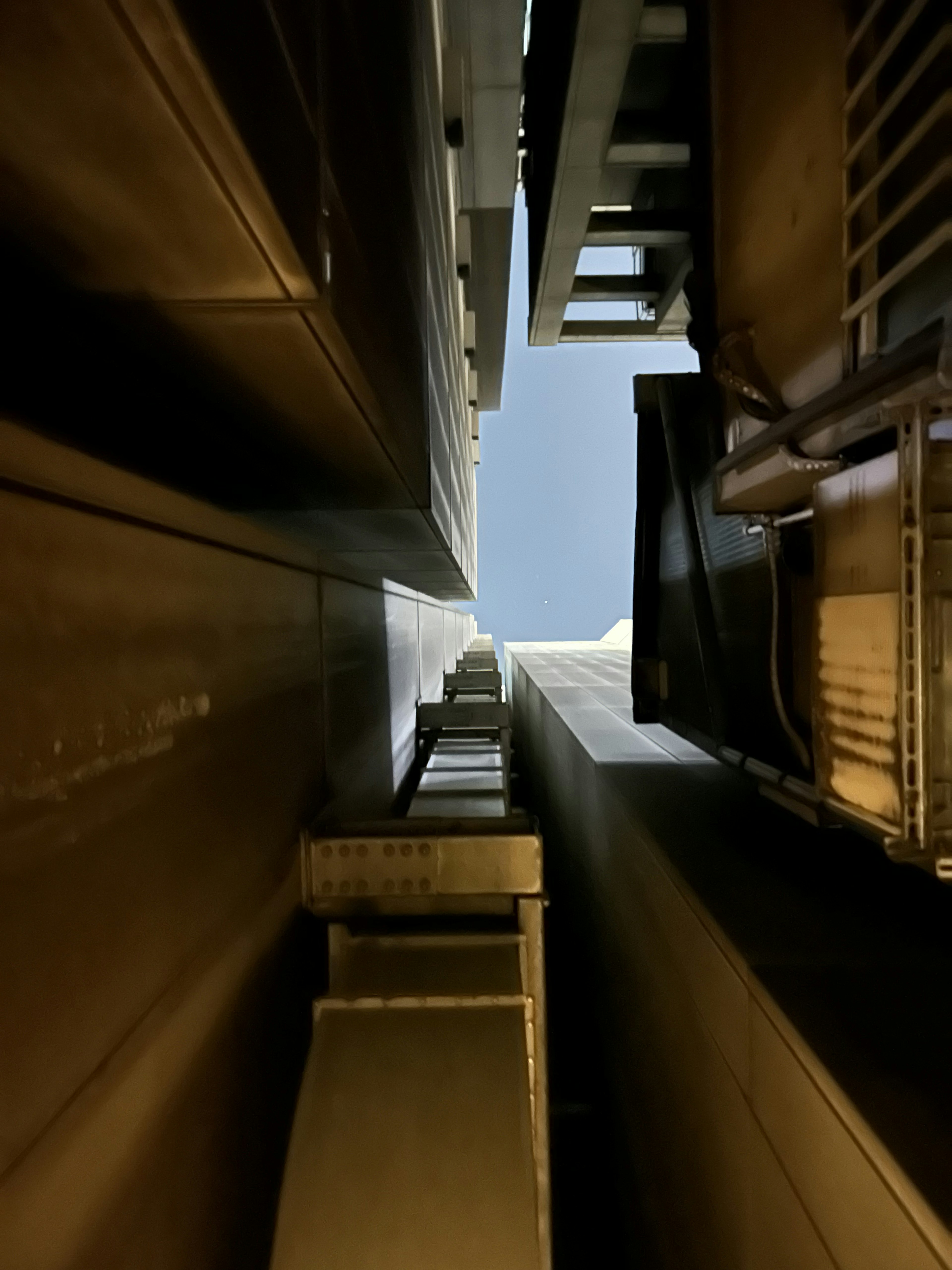 View looking up a narrow alley between tall buildings