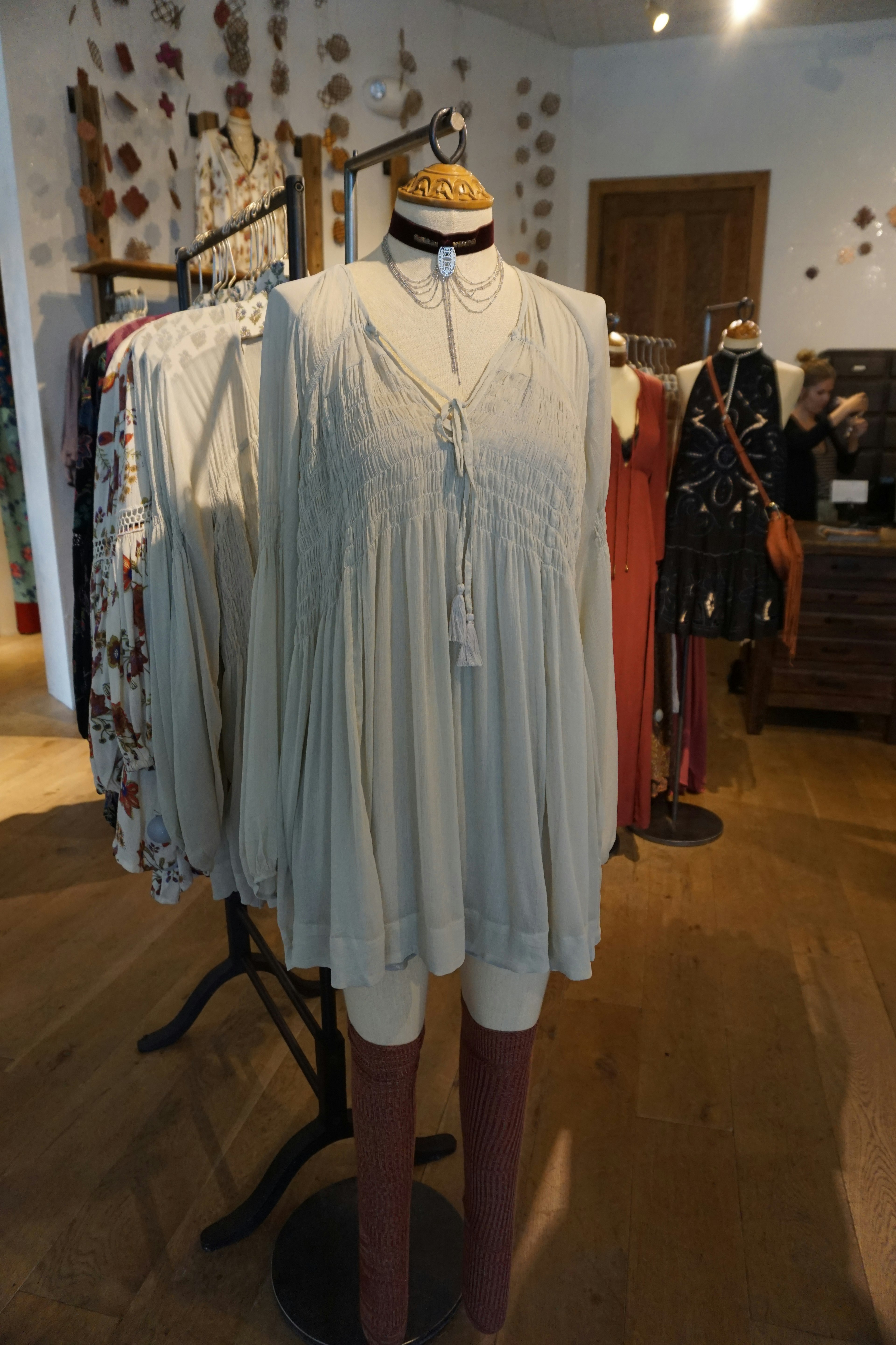 Display of a white dress and bronze-colored pants in a fashion store