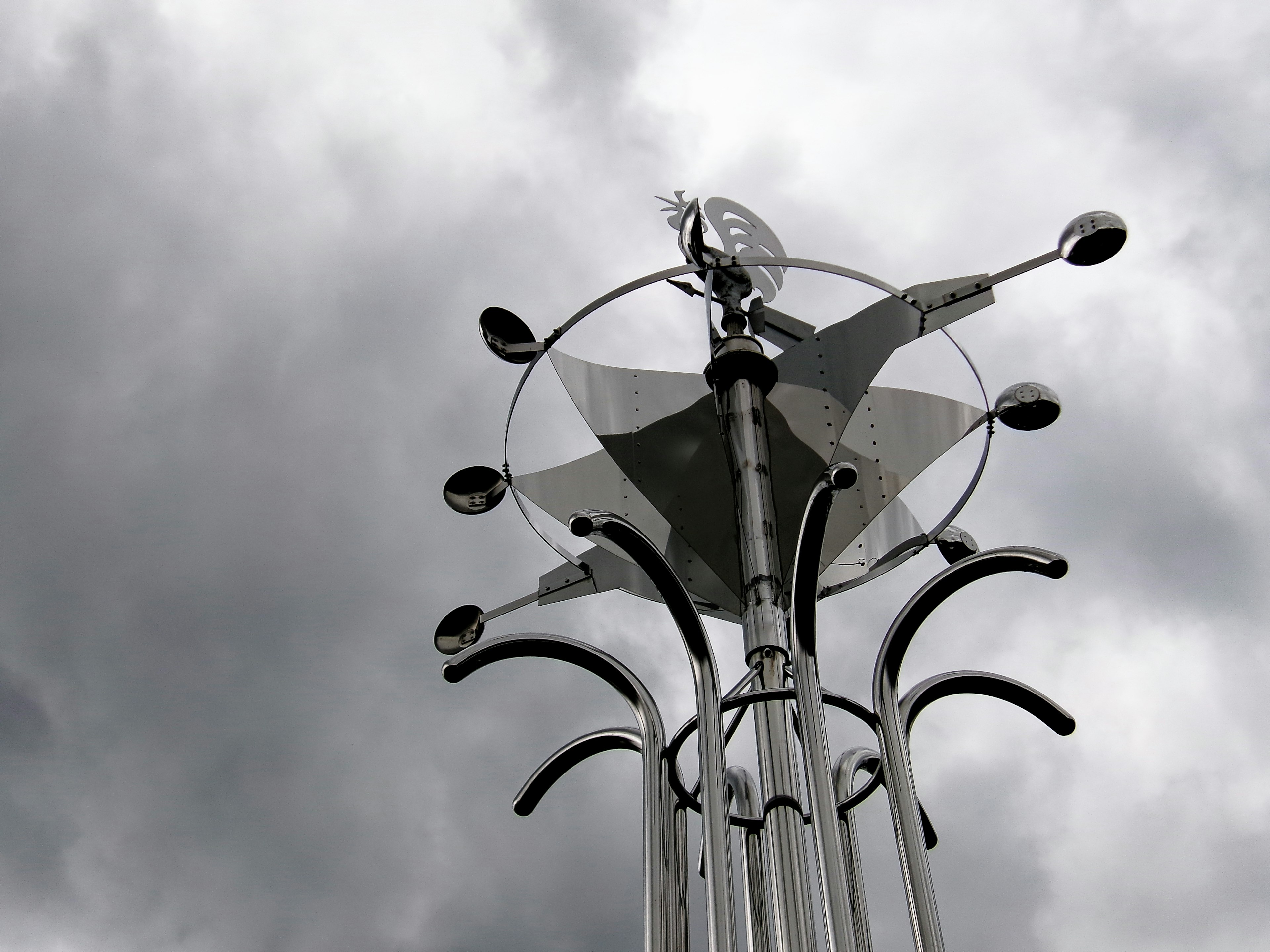 空に向かって伸びる金属製の彫刻と雲の背景