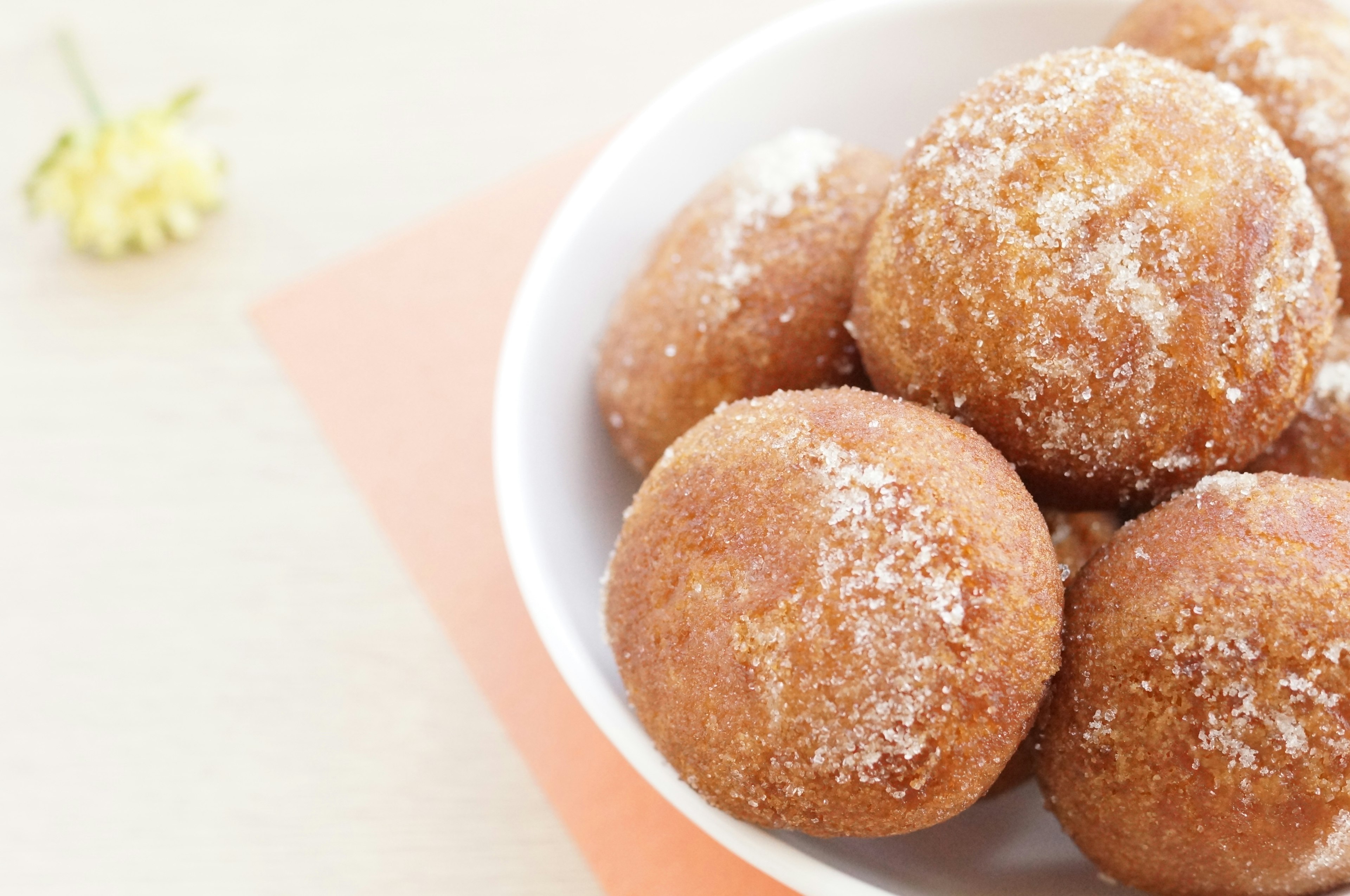 Un tazón de bolitas de masa frita cubiertas de azúcar