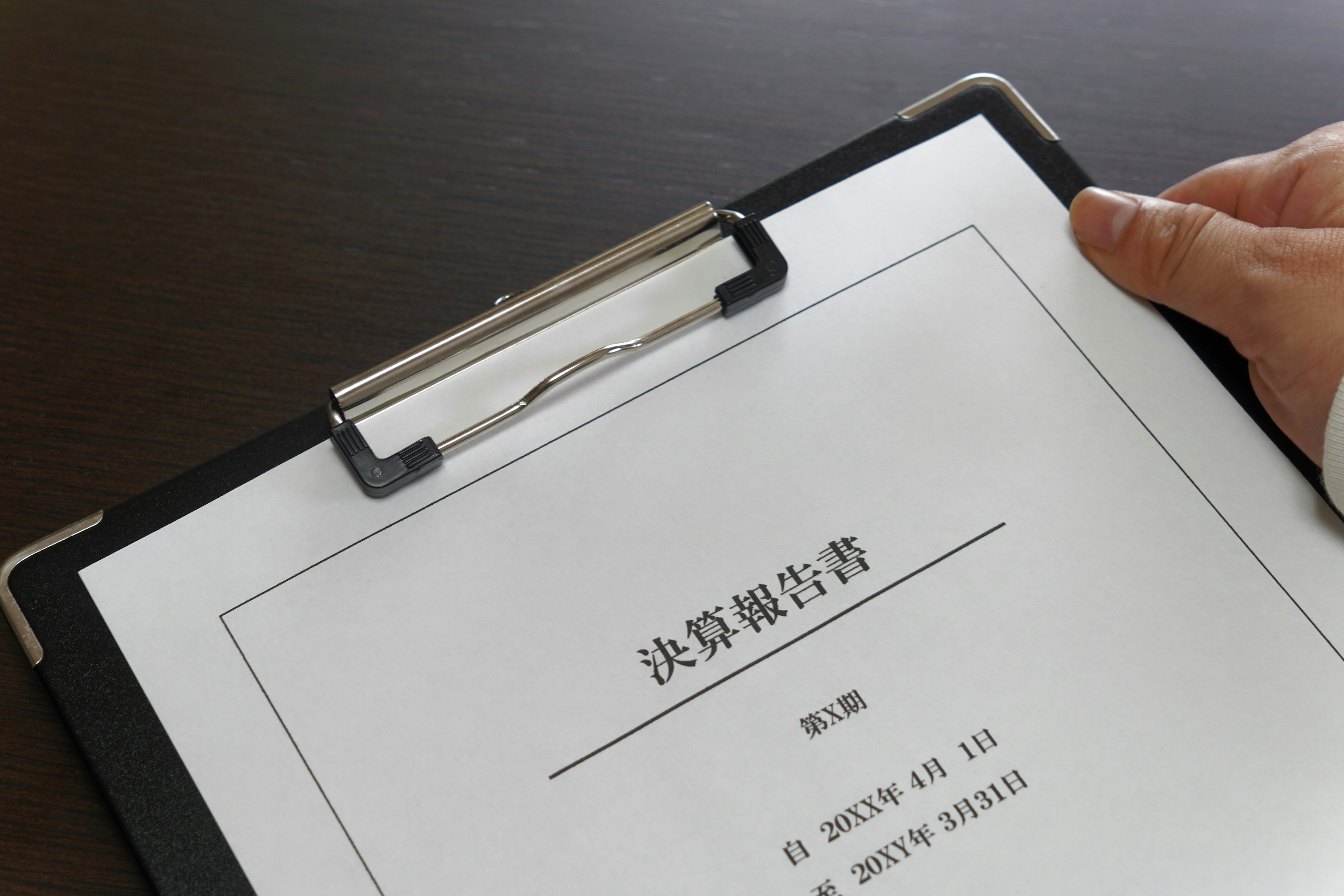 Image showing a hand holding a document on a clipboard