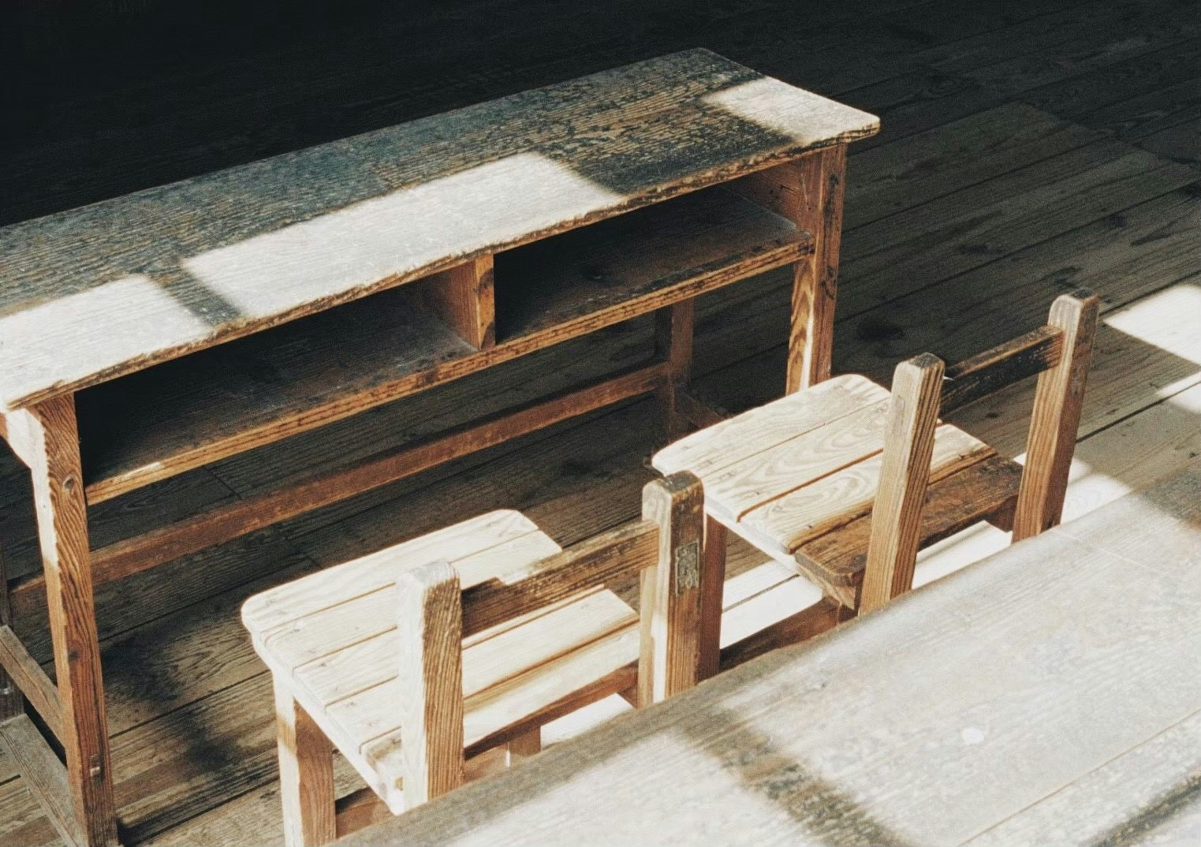 A simple interior scene featuring a wooden table and chairs