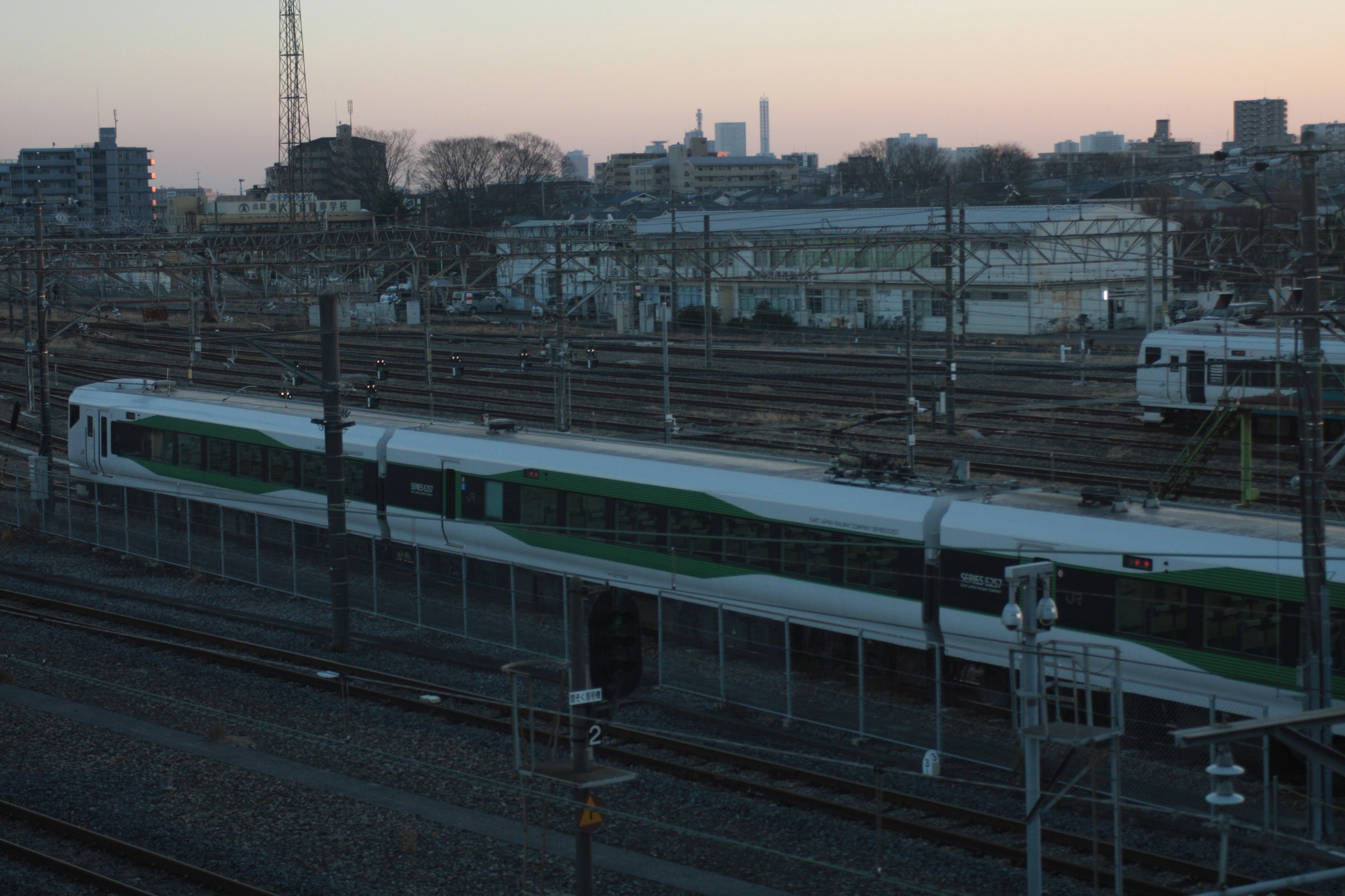 Train vert garé dans une gare ferroviaire au crépuscule