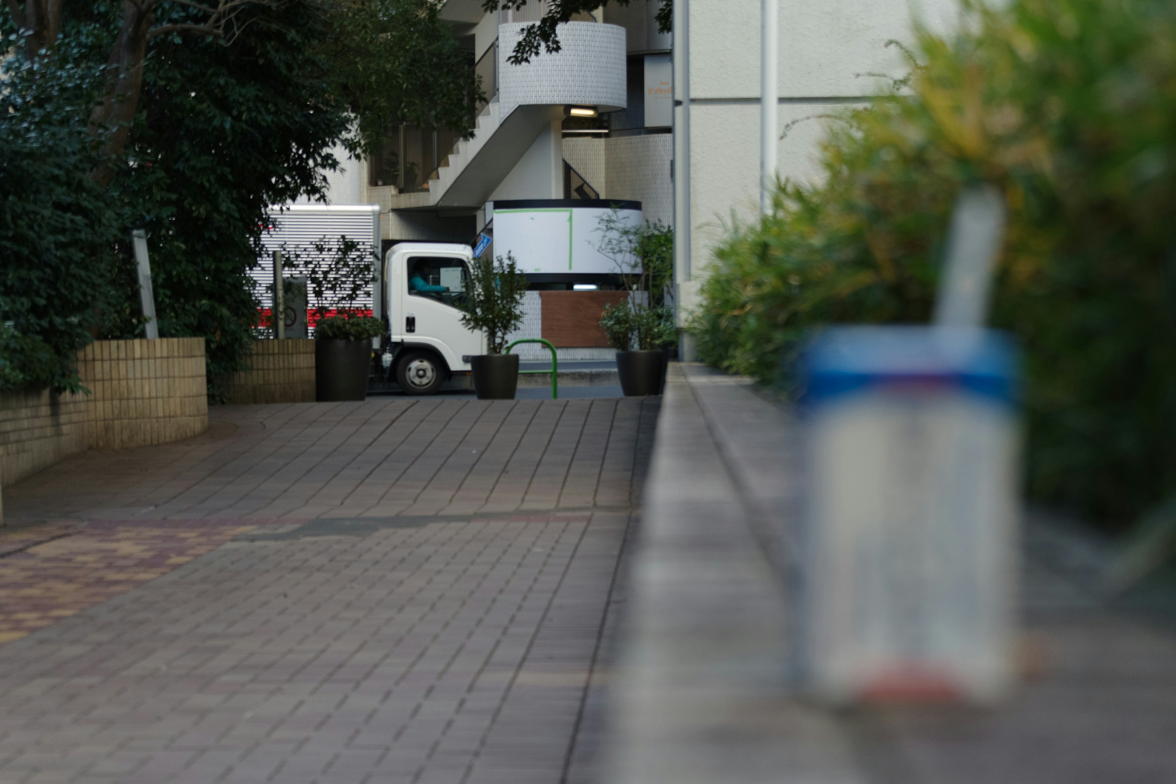 Close-up of a can with a building and stairs in the background