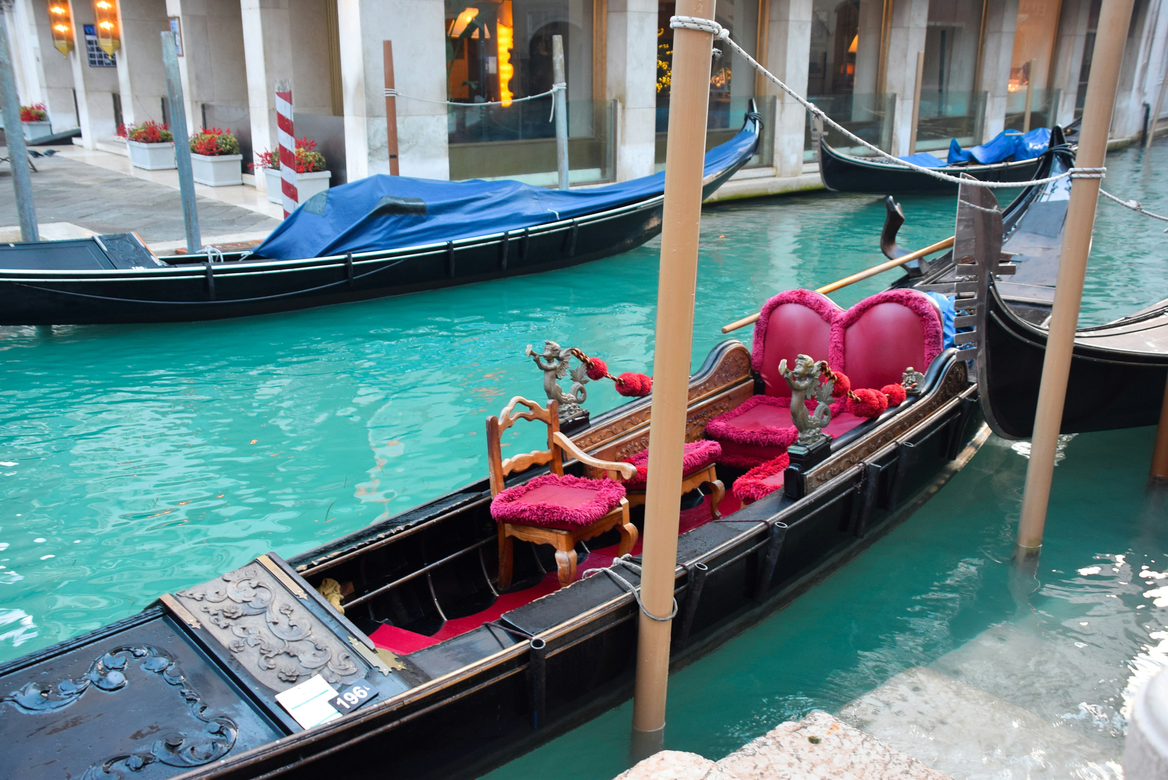 Beautiful gondola on a canal featuring red cushioned seats