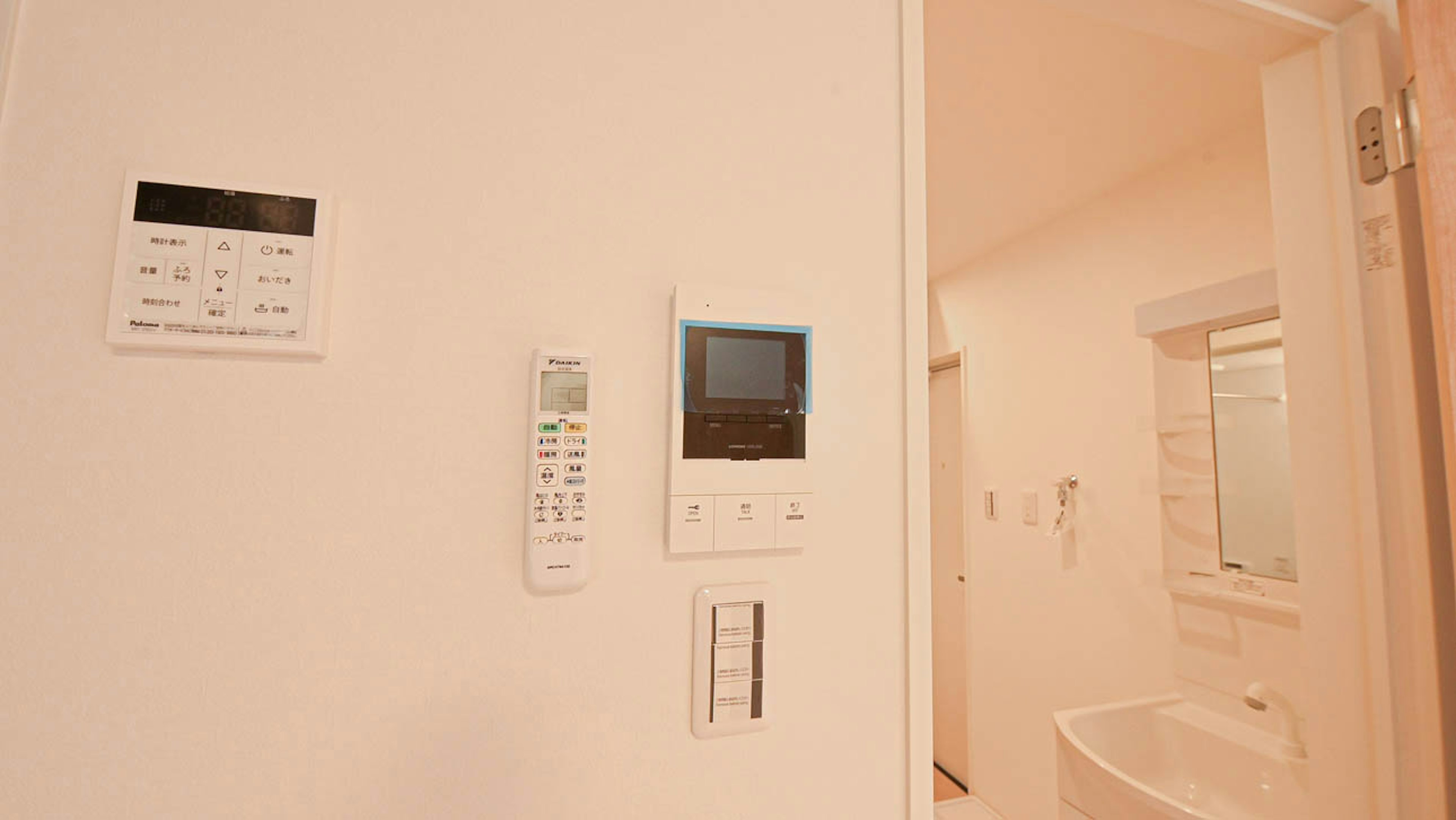 Photo of a white wall with a remote control and monitor