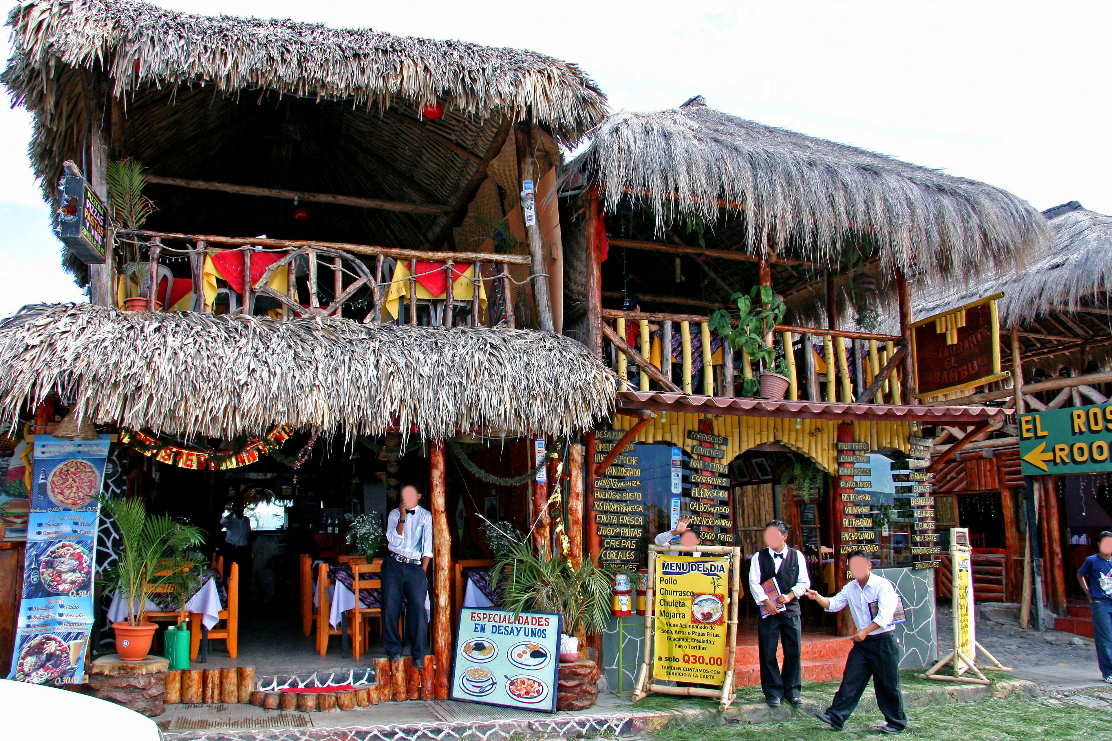 Exterior de restaurante de estilo tropical con techo de paja y decoraciones coloridas