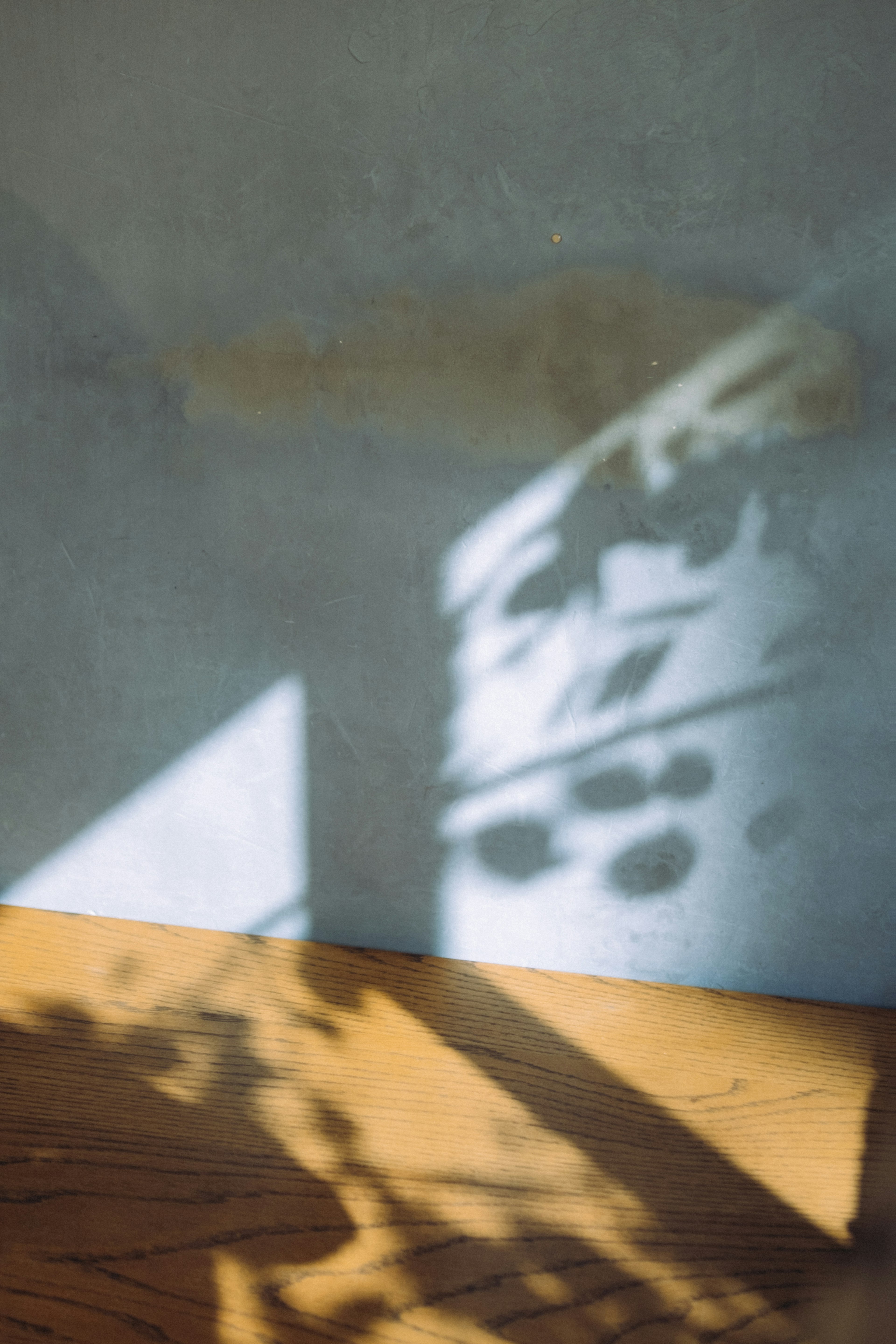 A simple indoor scene with shadows projected on the wall and floor