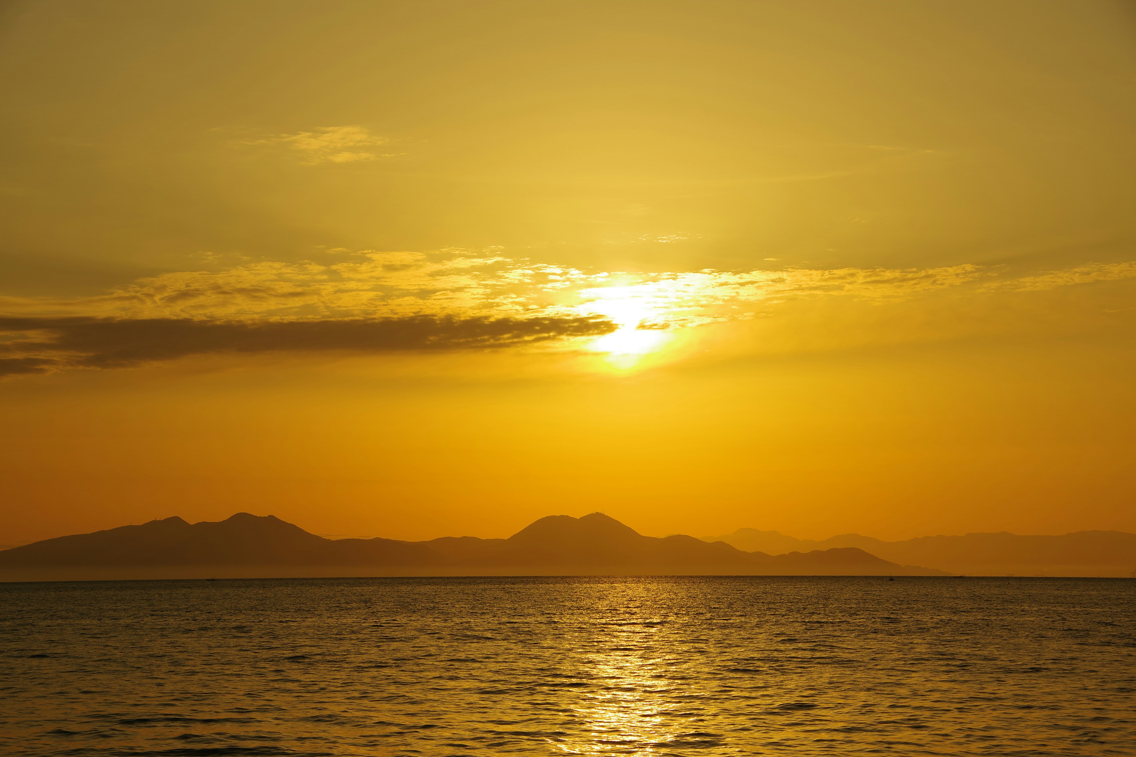 Beautiful sunset over the ocean with orange sky and mountains