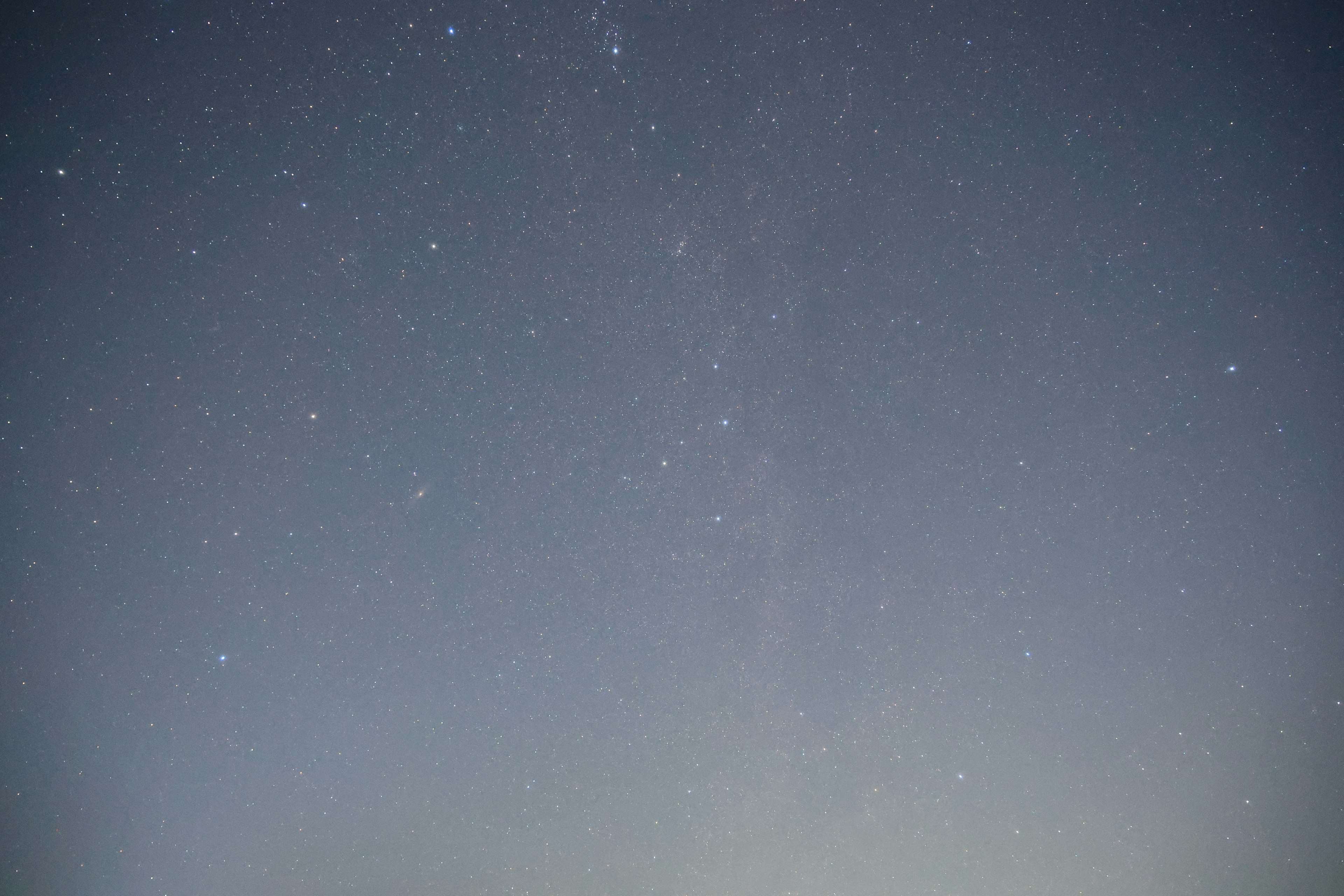 Una foto del cielo notturno con stelle sparse su uno sfondo blu chiaro