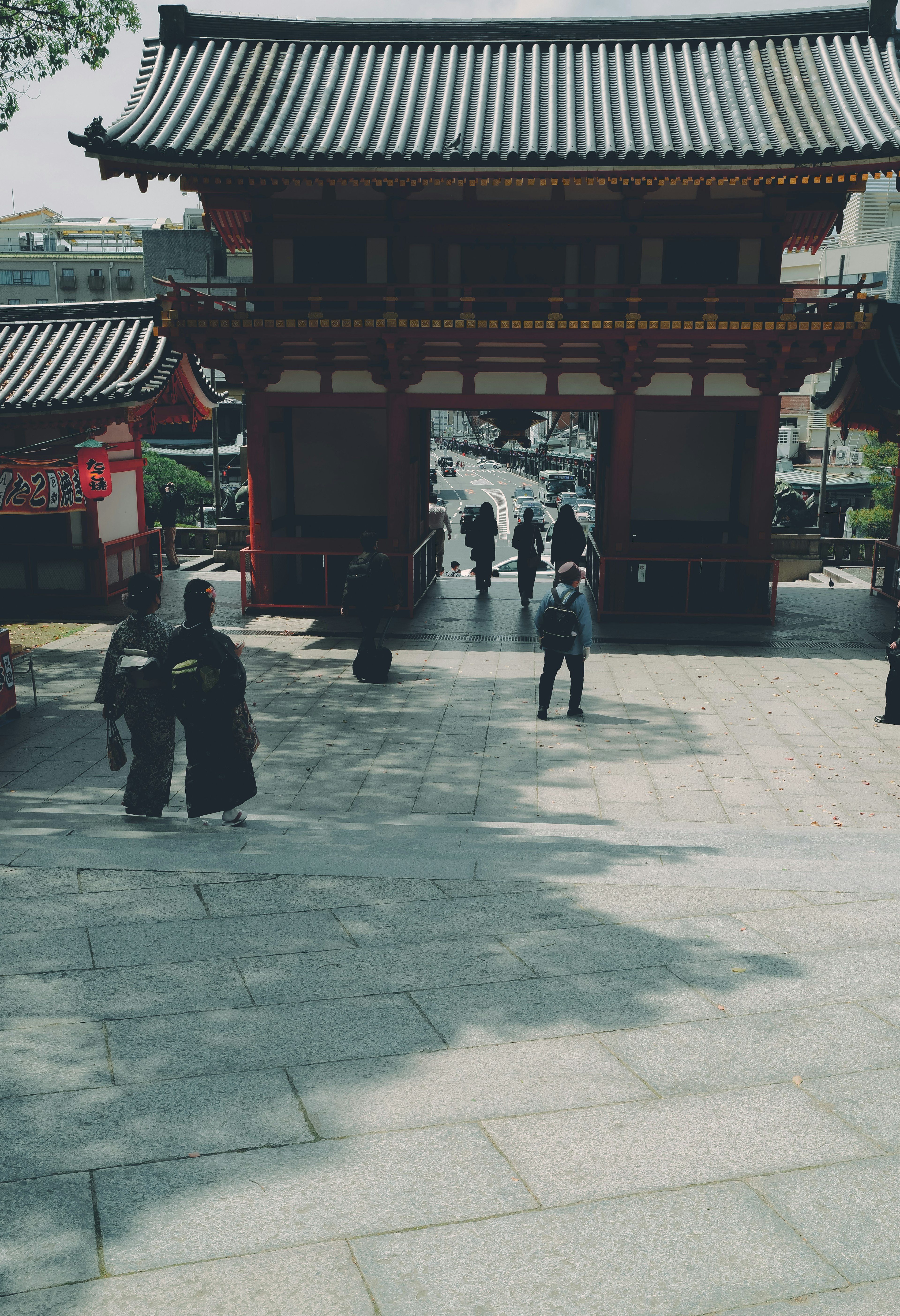 People in kimonos walking through a traditional Japanese gate