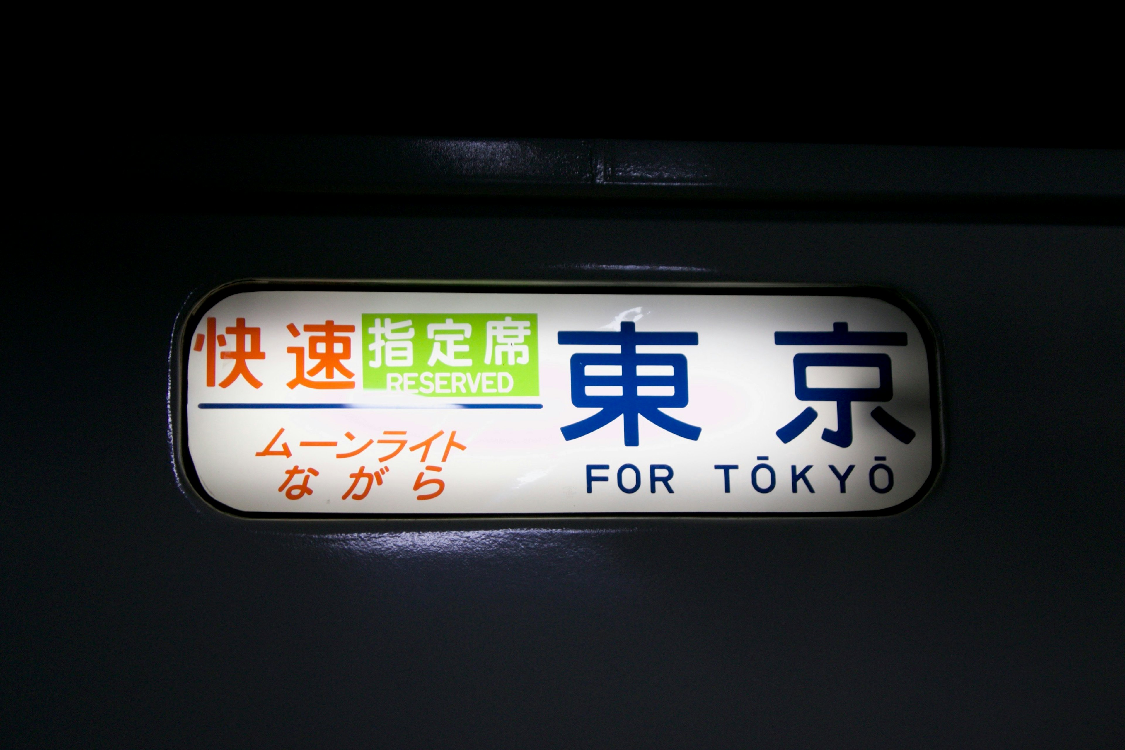 Panneau de train pour Tokyo avec du texte bleu proéminent