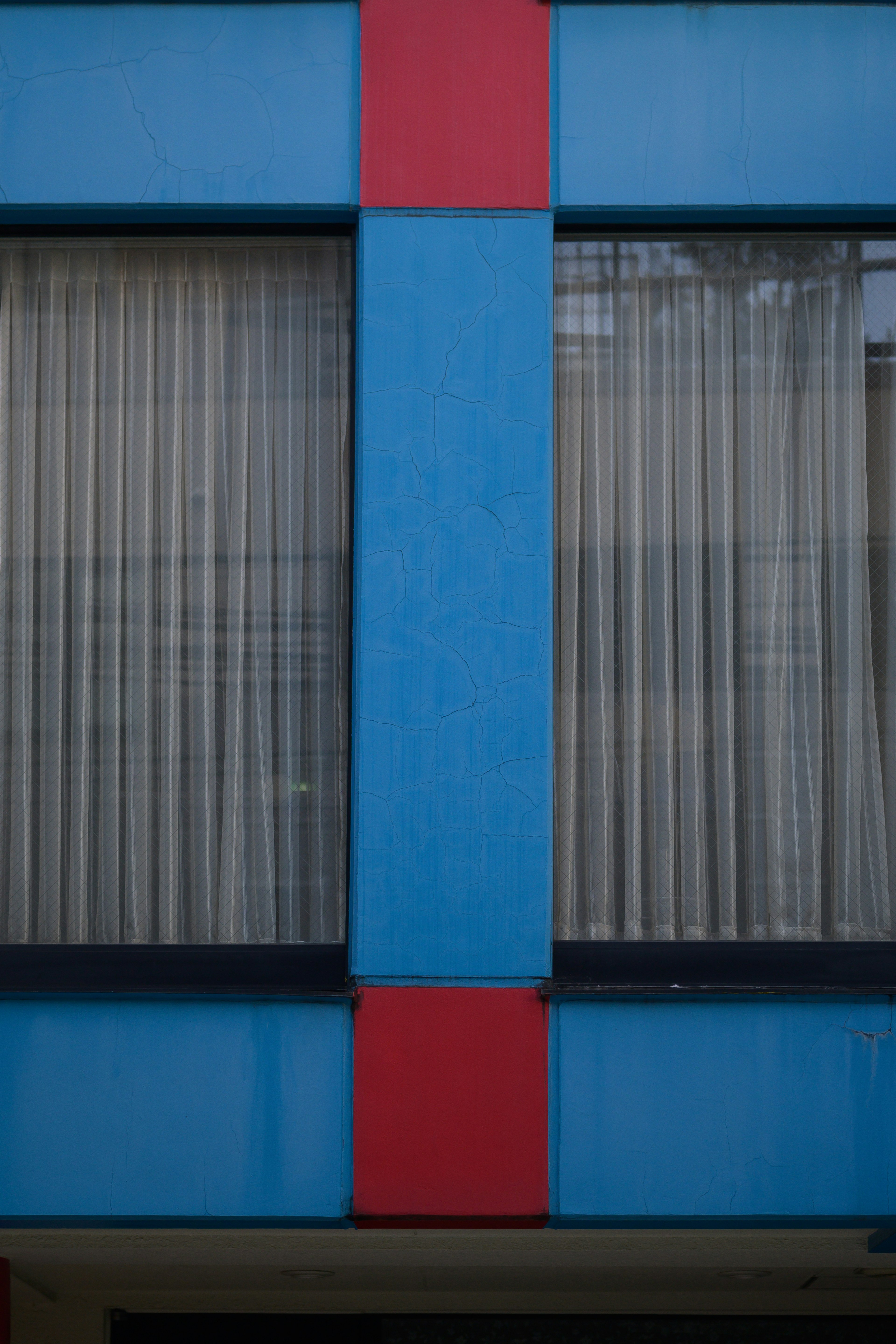 Window of a building featuring blue and red stripes