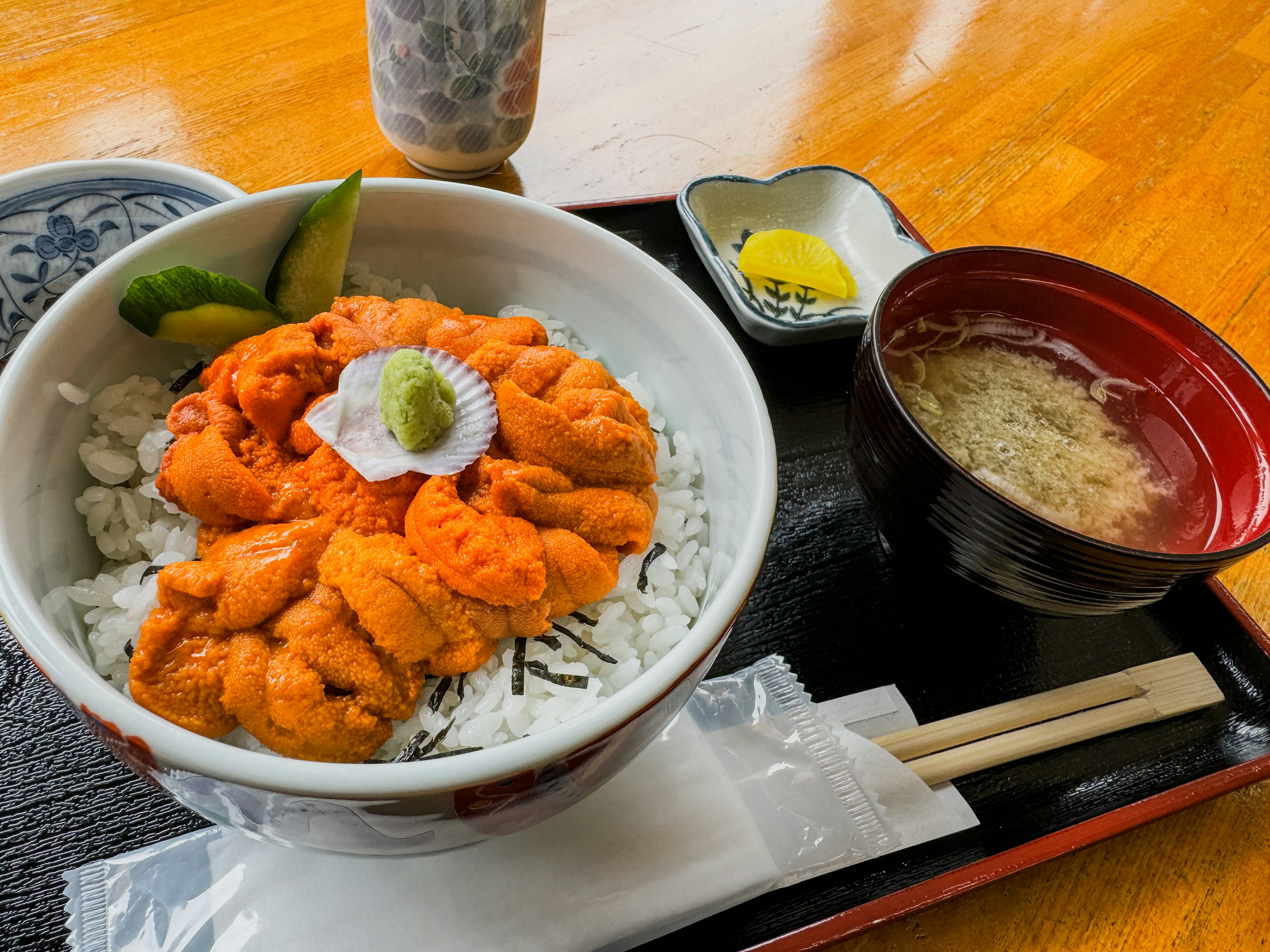 一碗美味的海胆放在白米饭上，装饰有芥末