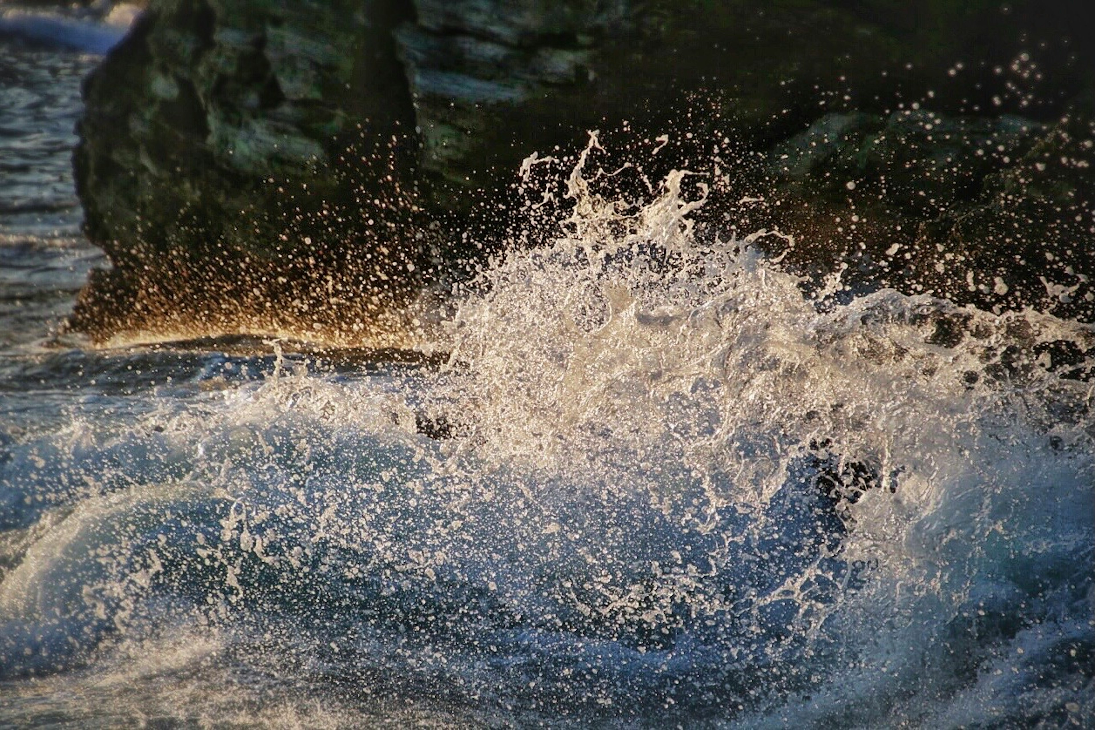 海浪冲击岩石溅起水花的景象