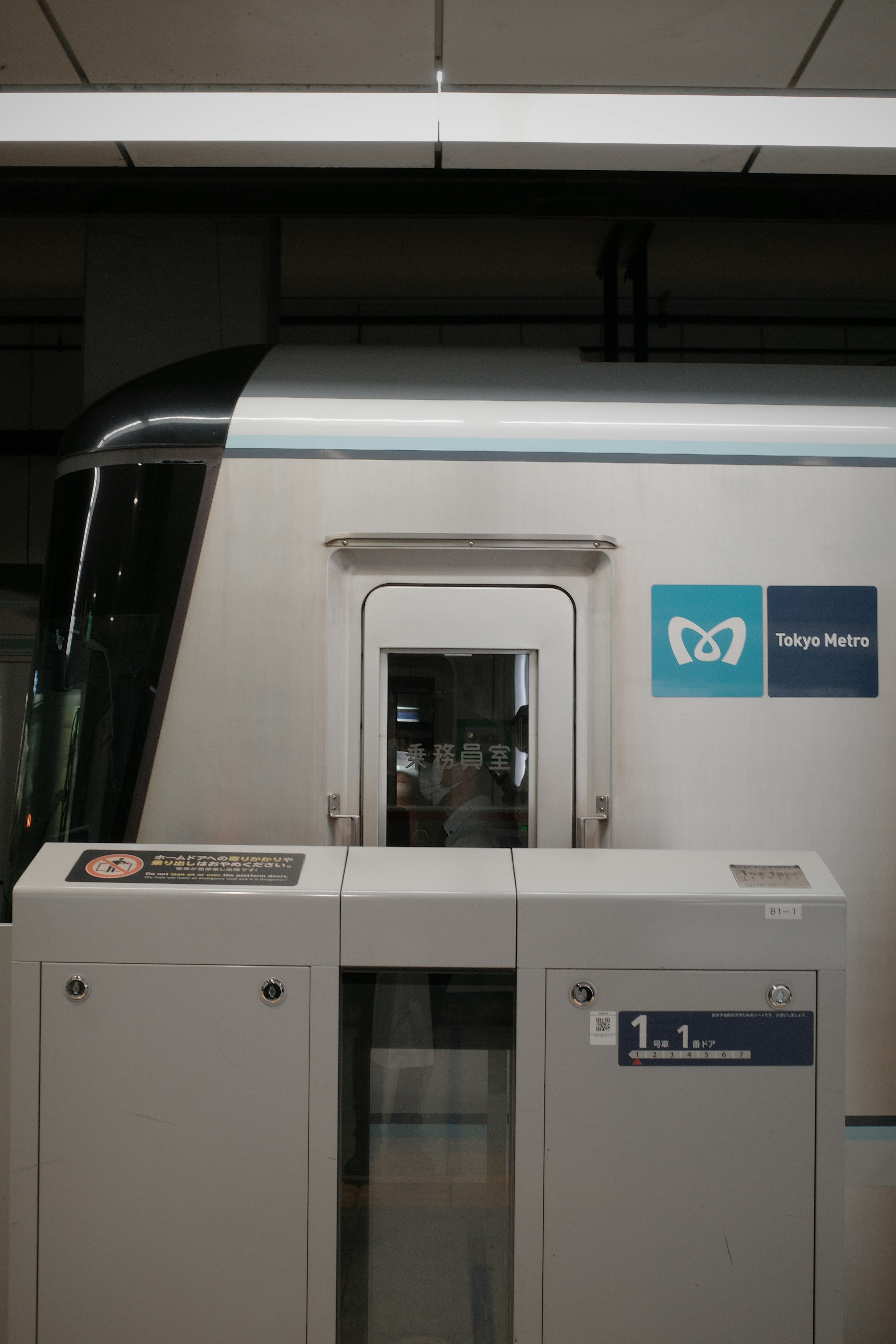 Frente de un tren en una estación con una máquina expendedora de boletos