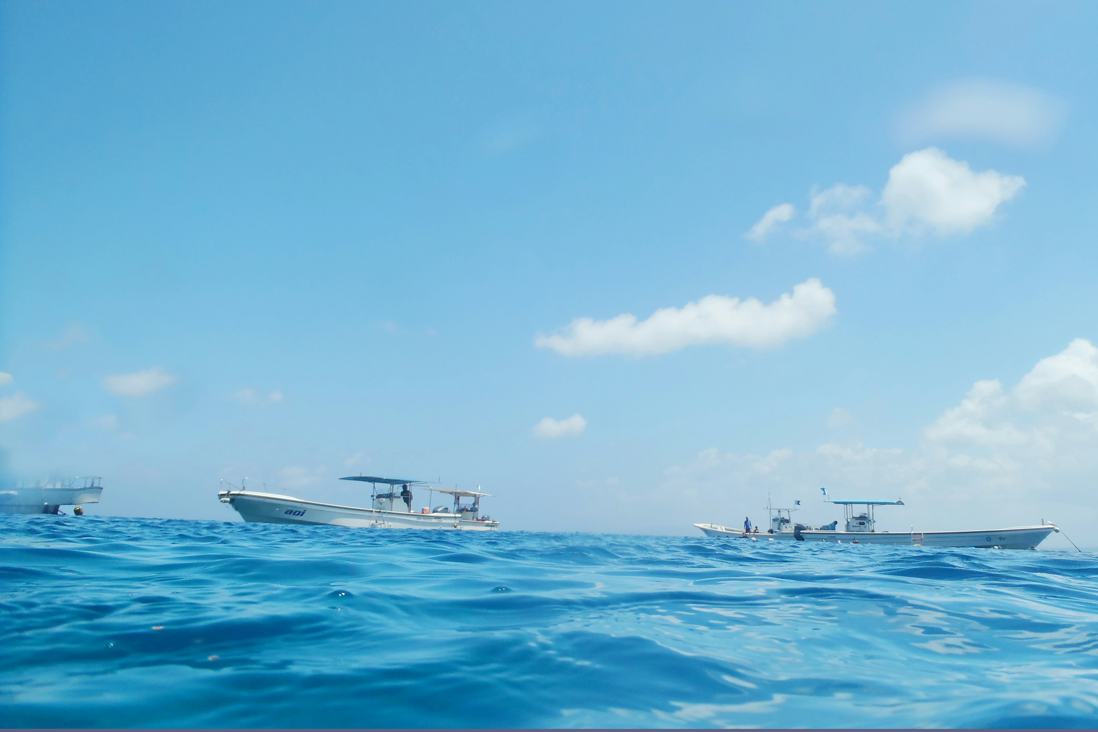 Boote, die auf einem blauen Meer unter einem klaren Himmel schwimmen