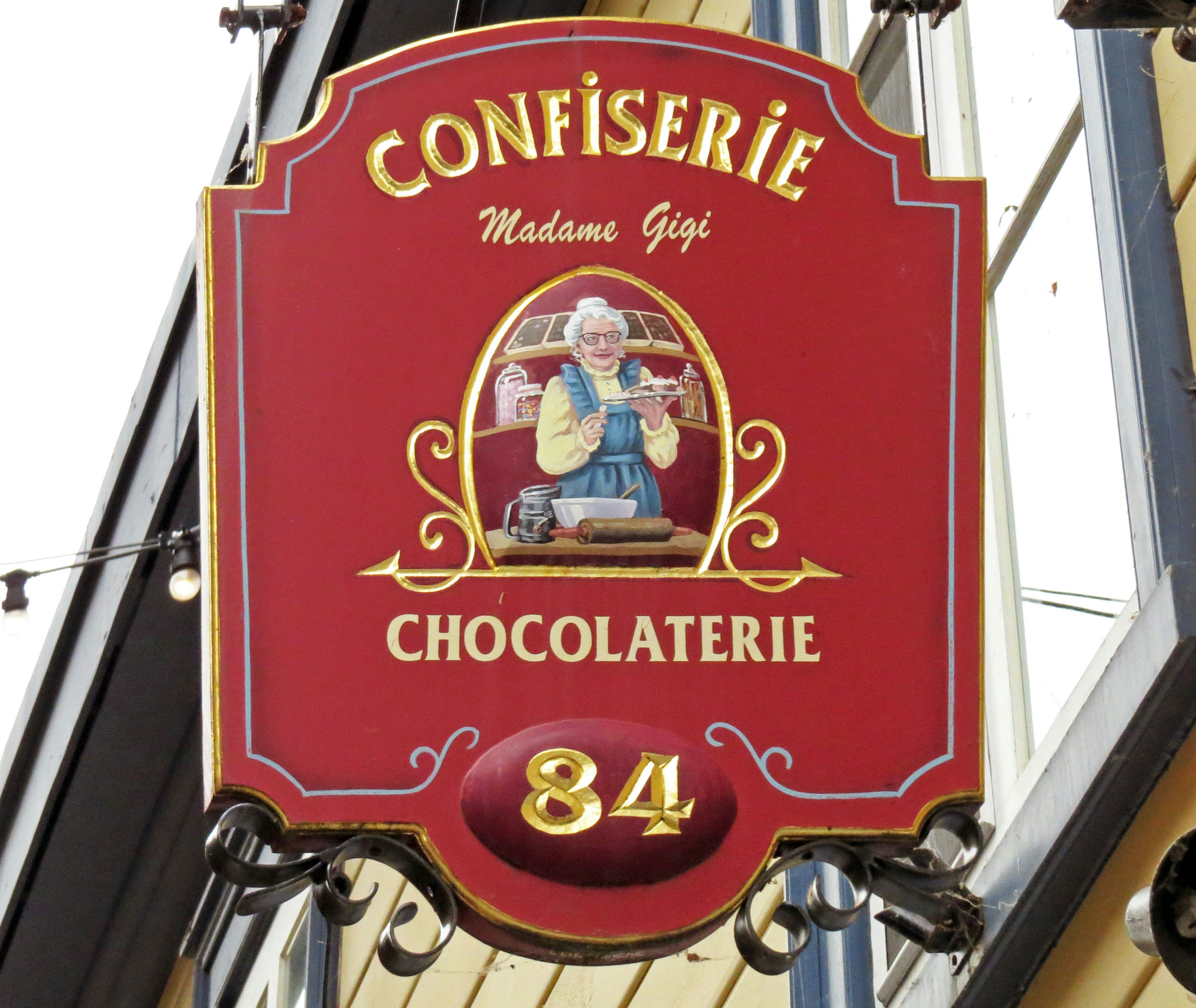 Red sign featuring a chocolatier illustration with the number 84