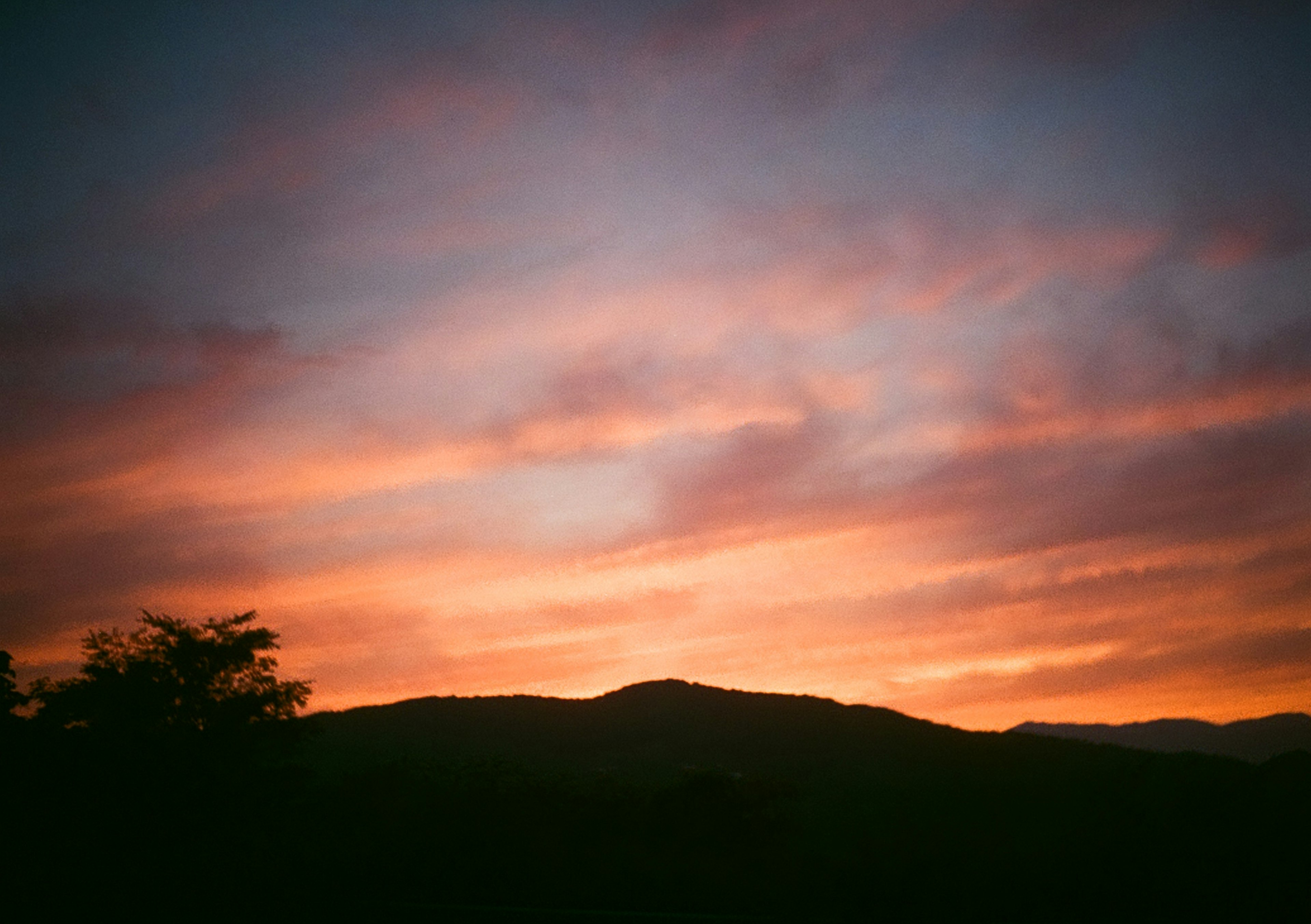 夕焼けの山と色とりどりの雲