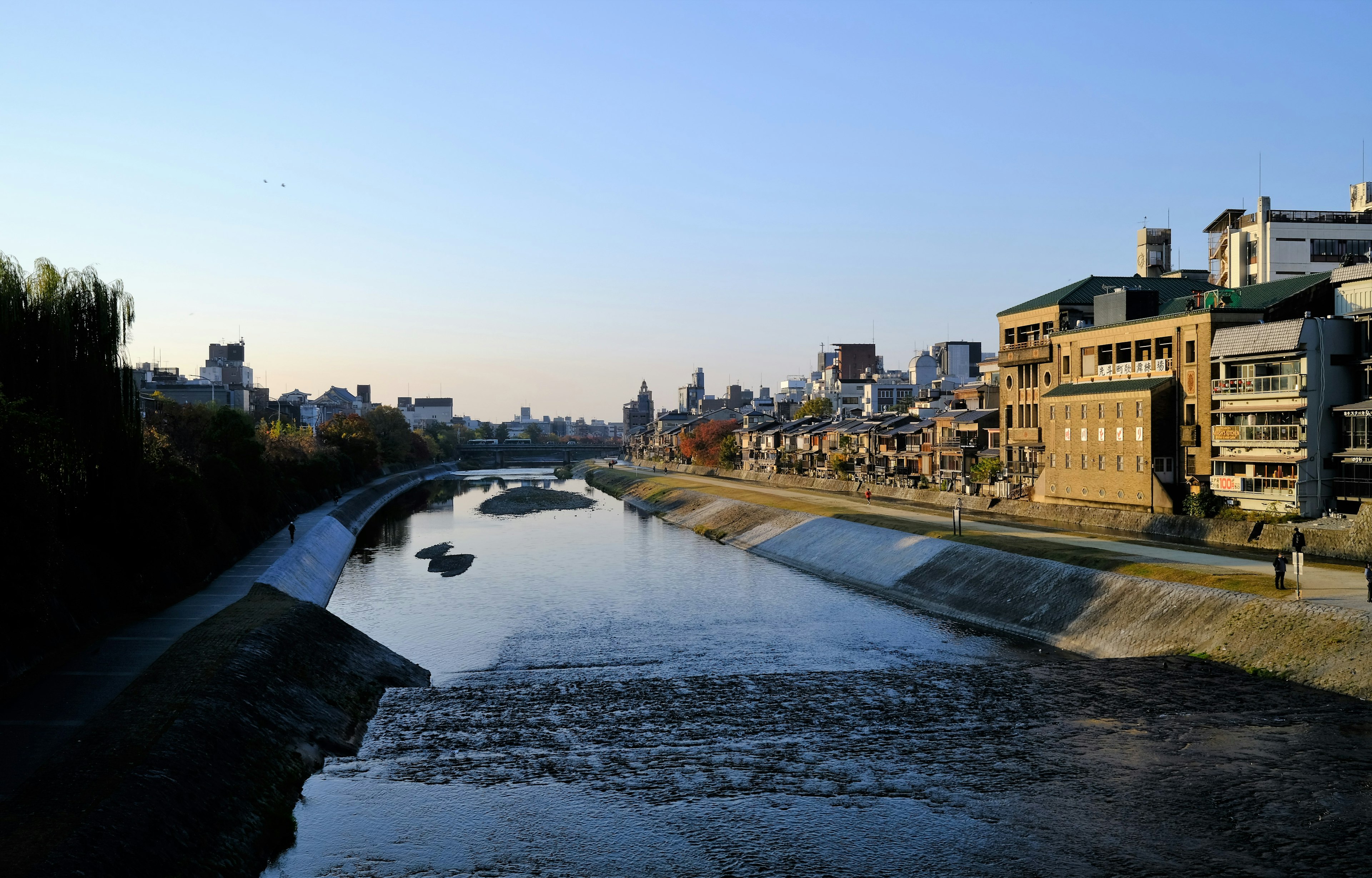 Vue du soir sur un paysage fluvial avec des bâtiments urbains