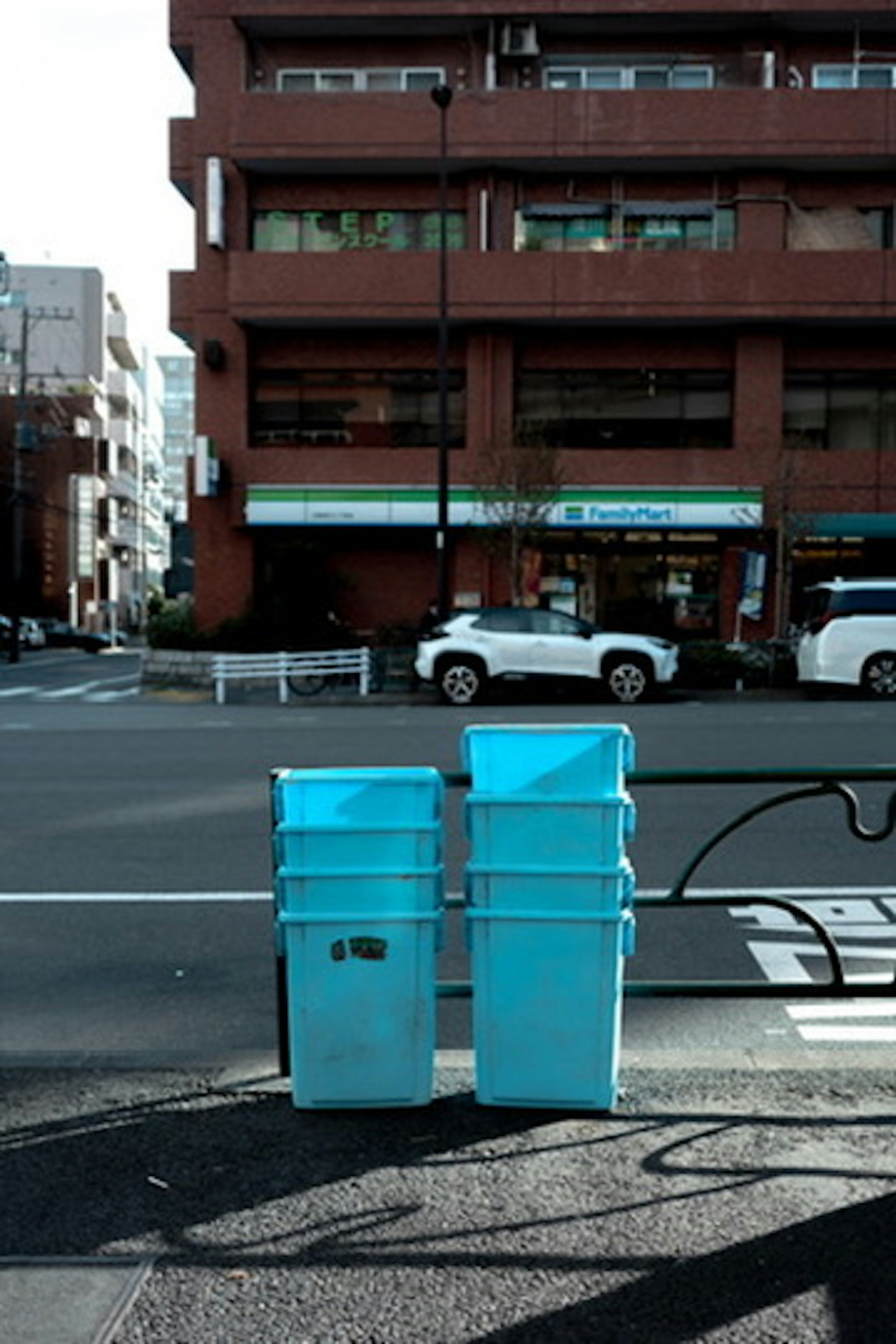 青いゴミ箱が並ぶ街角の風景