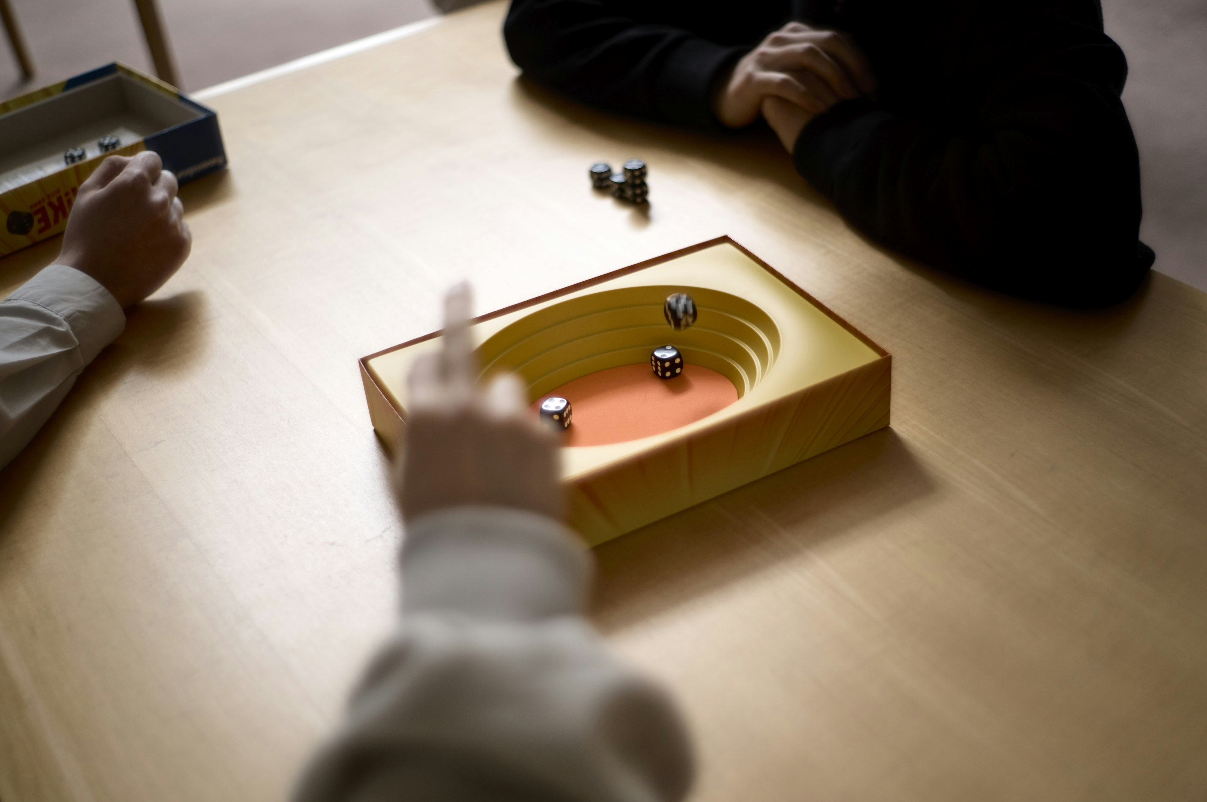 Hands of players engaged in a game on a yellow board