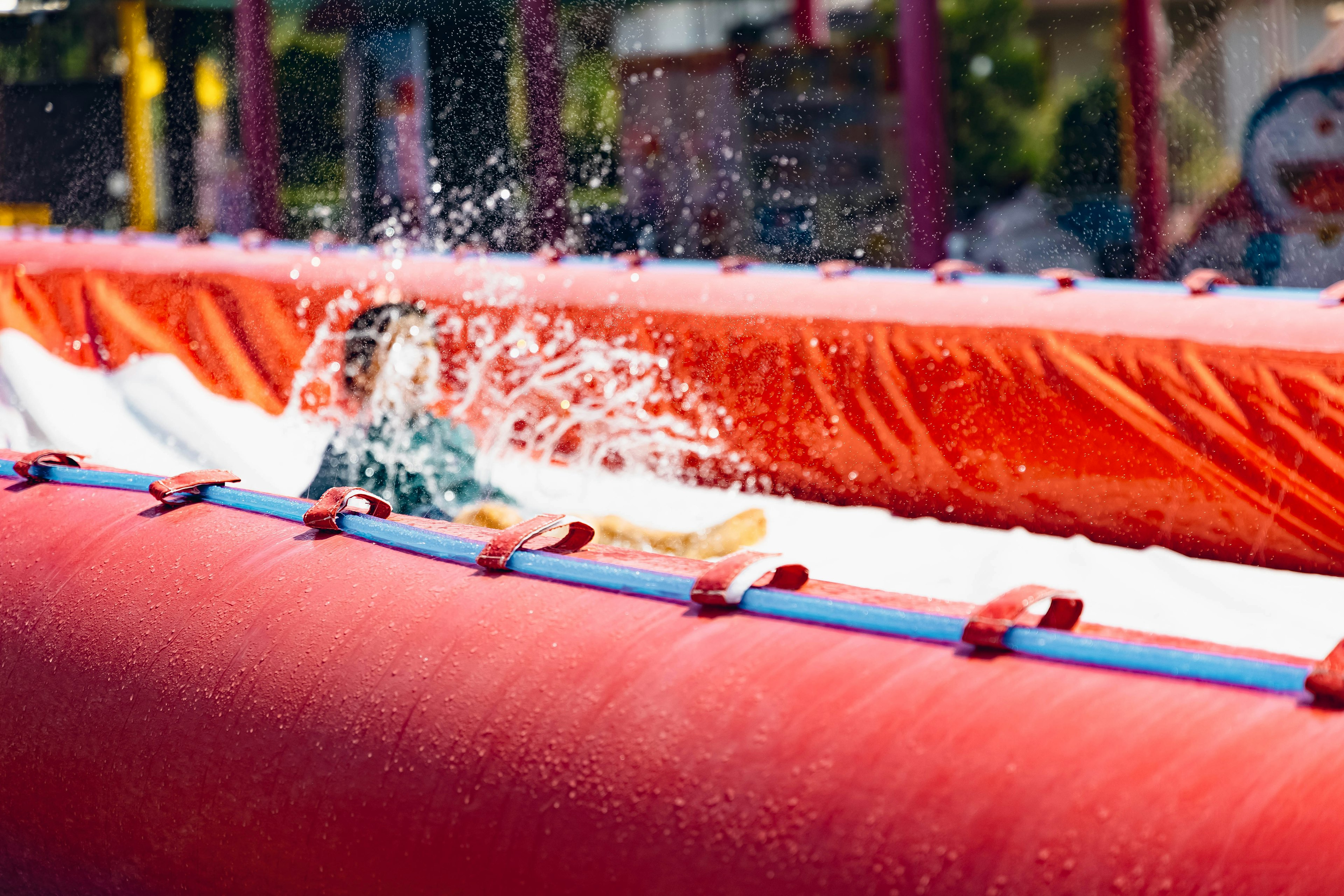 Enfant éclaboussant de l'eau sur un toboggan rouge