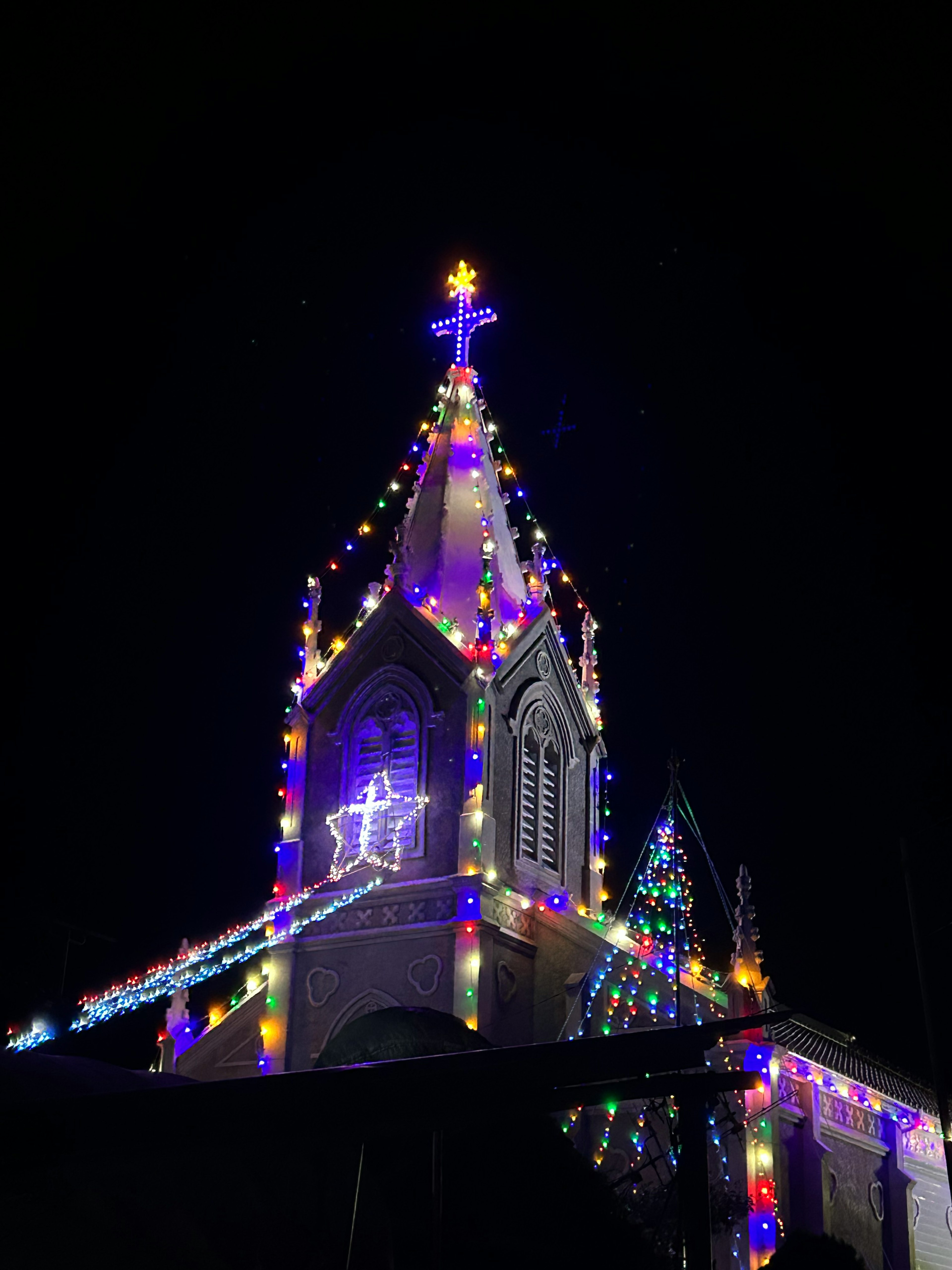 Colorful Christmas lights and star decorations on a church at night