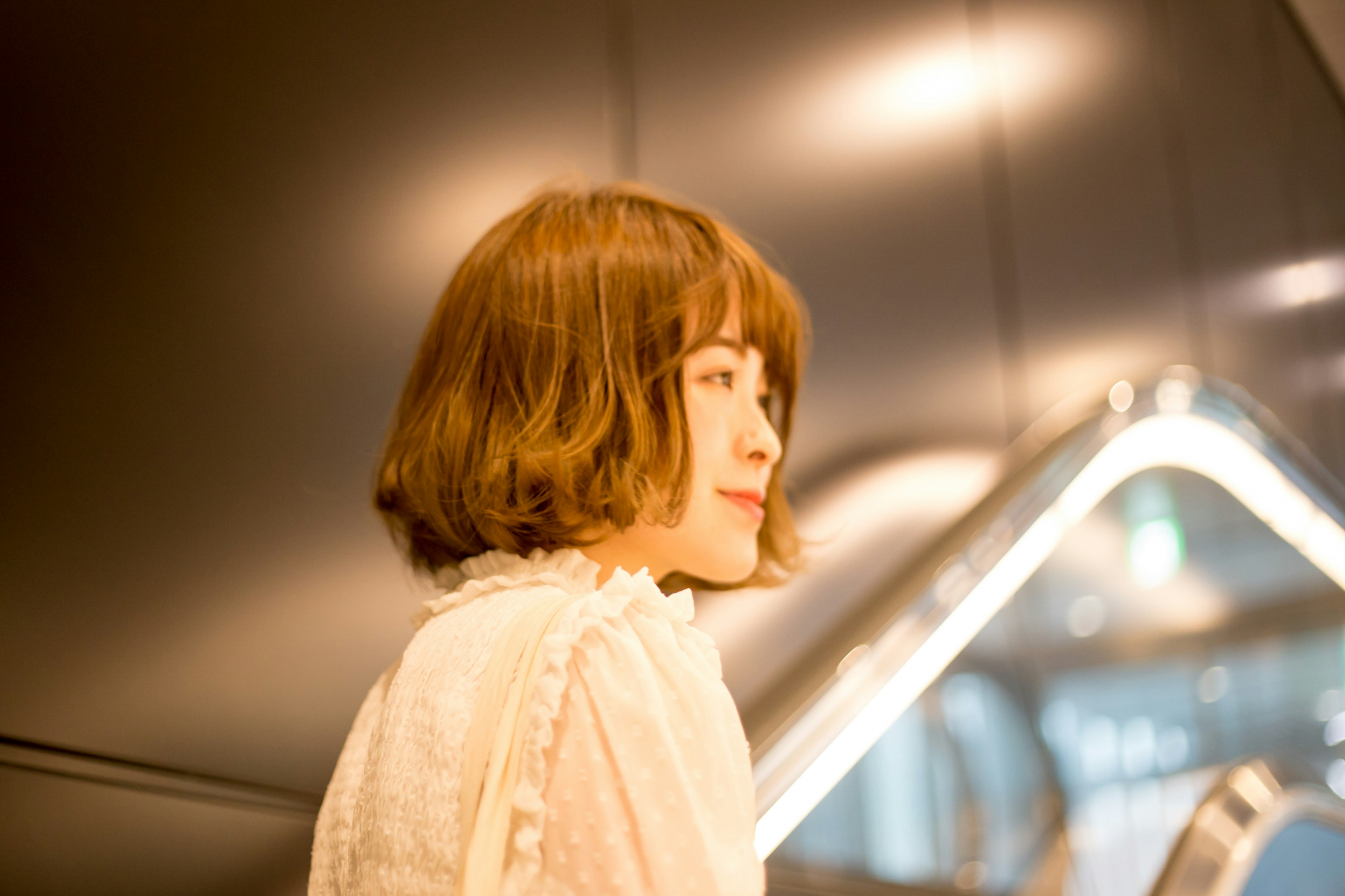 Young woman smiling while facing sideways with modern interior in the background