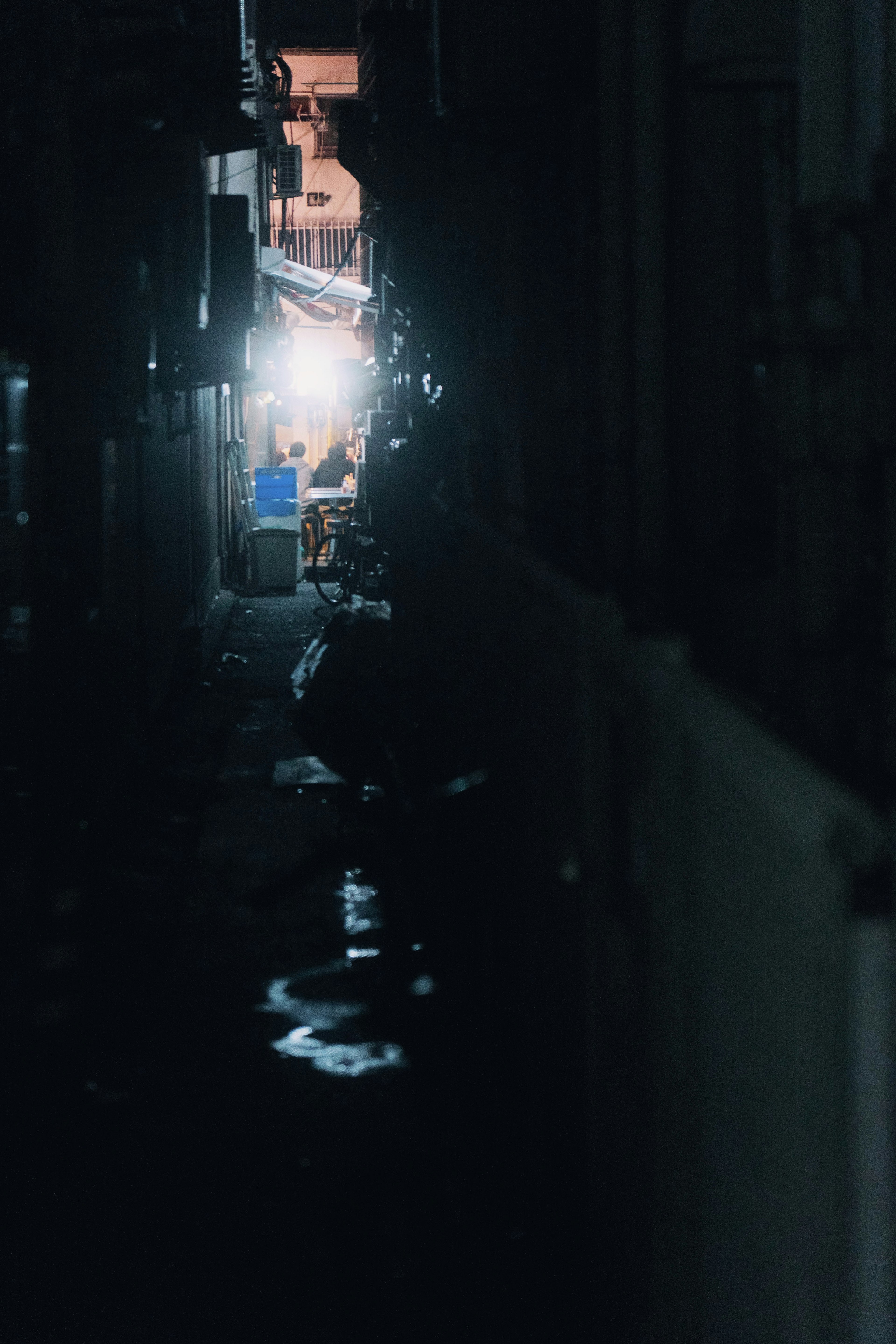 Narrow alley illuminated by bright light in the distance