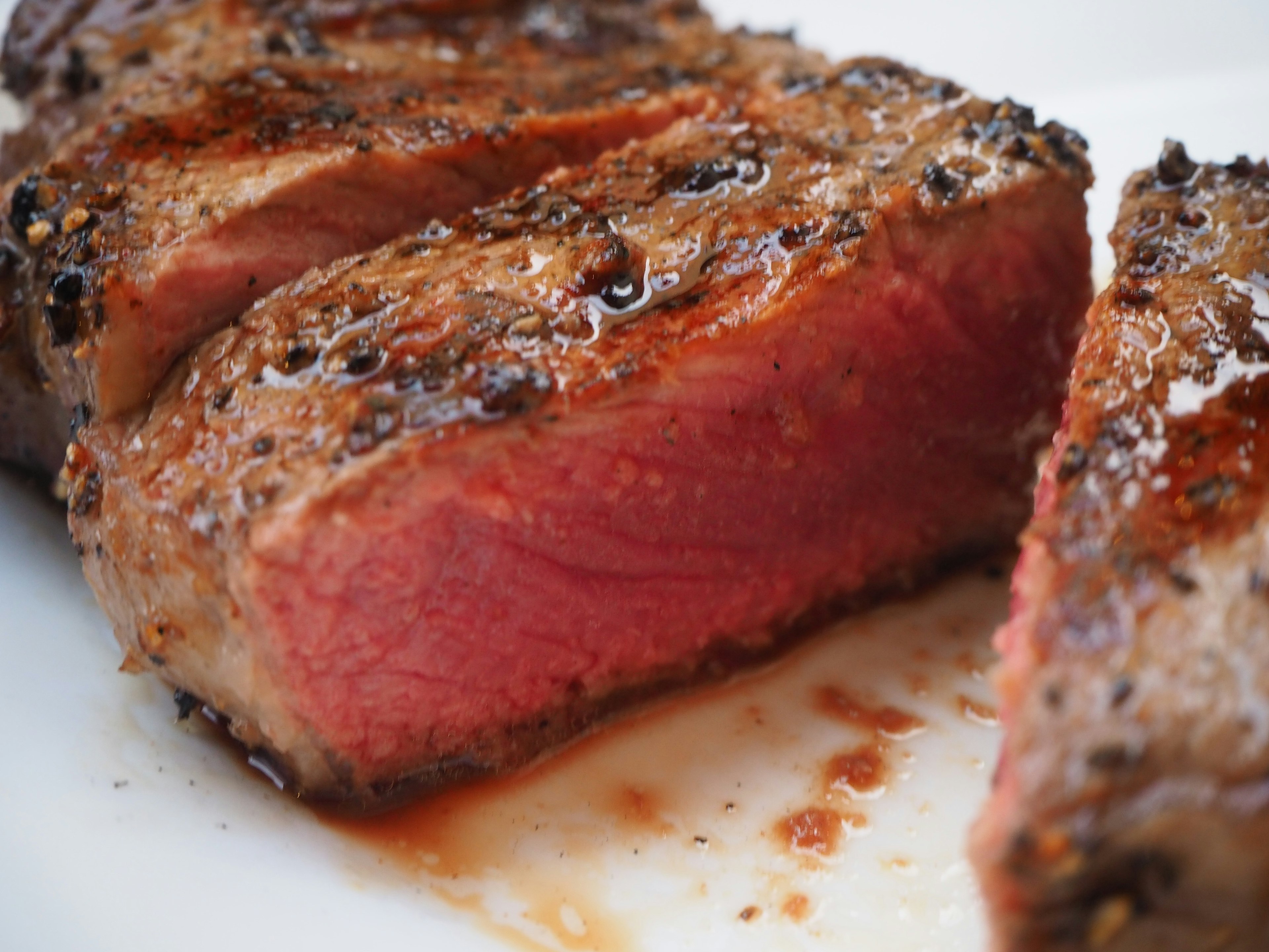 Bistec jugoso con marcas de parrilla que muestra un interior rosado