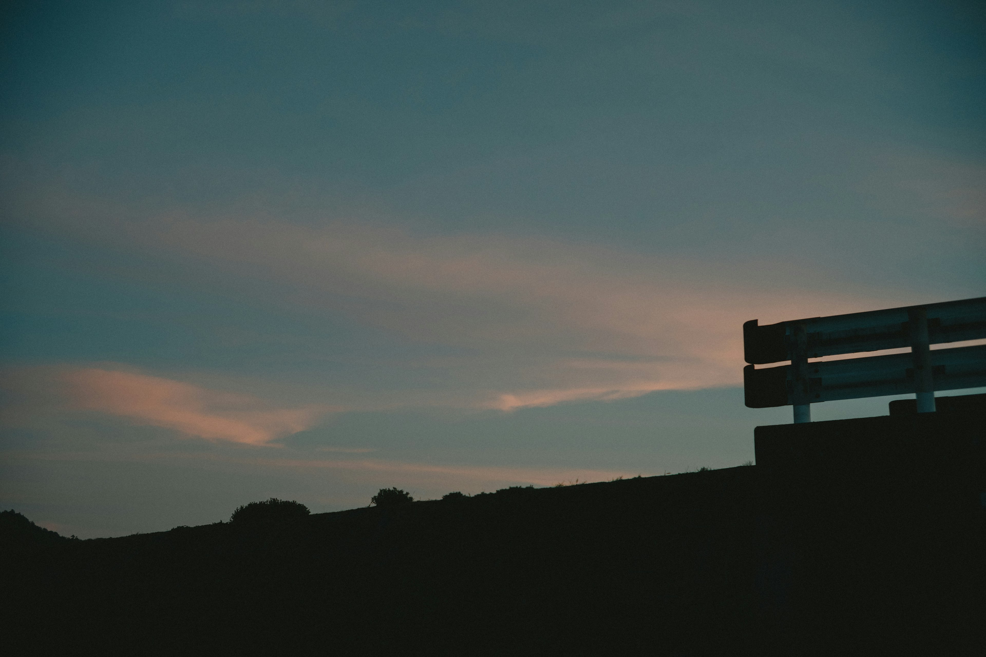 Silueta de un banco contra un cielo crepuscular