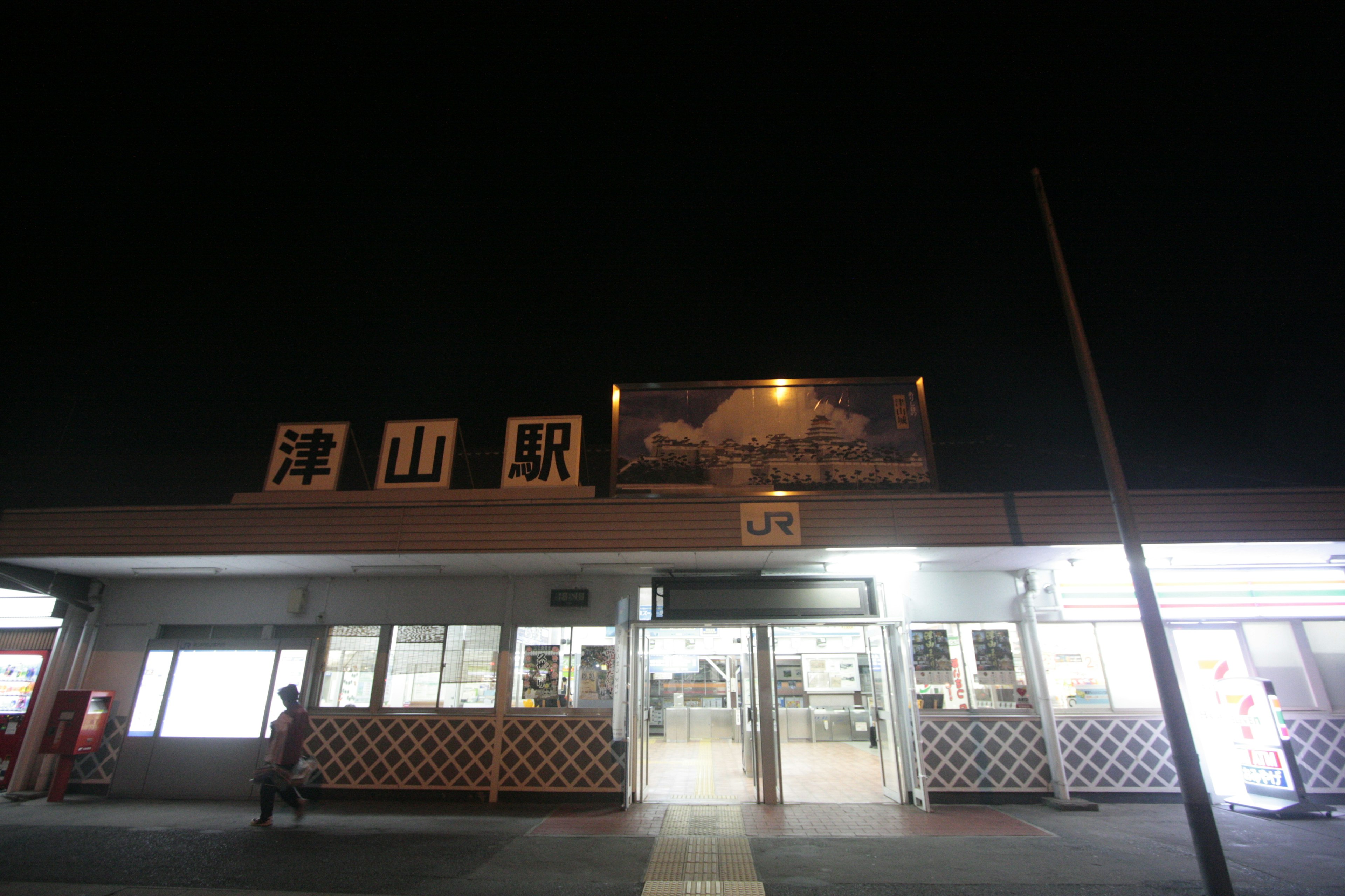 Vista notturna di una stazione tranquilla con il nome della stazione Seizan grande insegna e finestre luminose