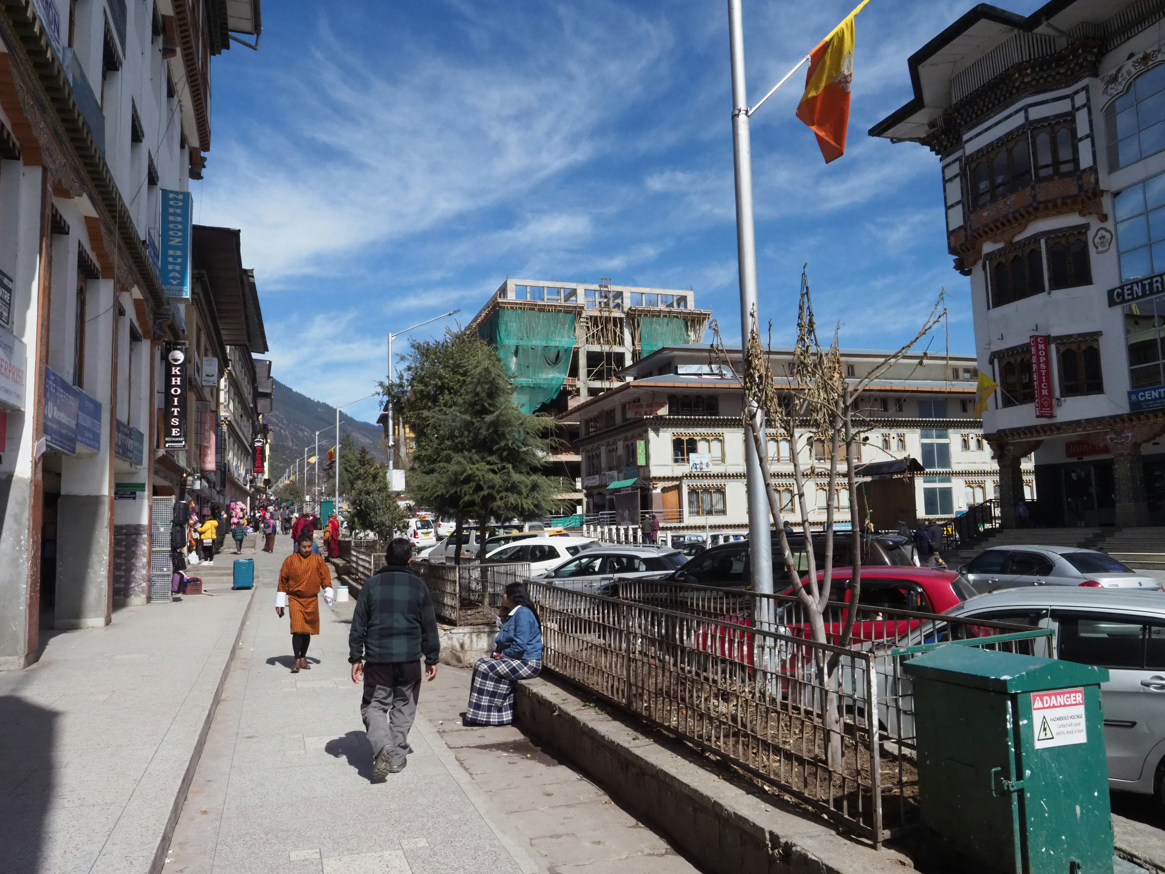 Escena de calle con peatones y cielo azul claro