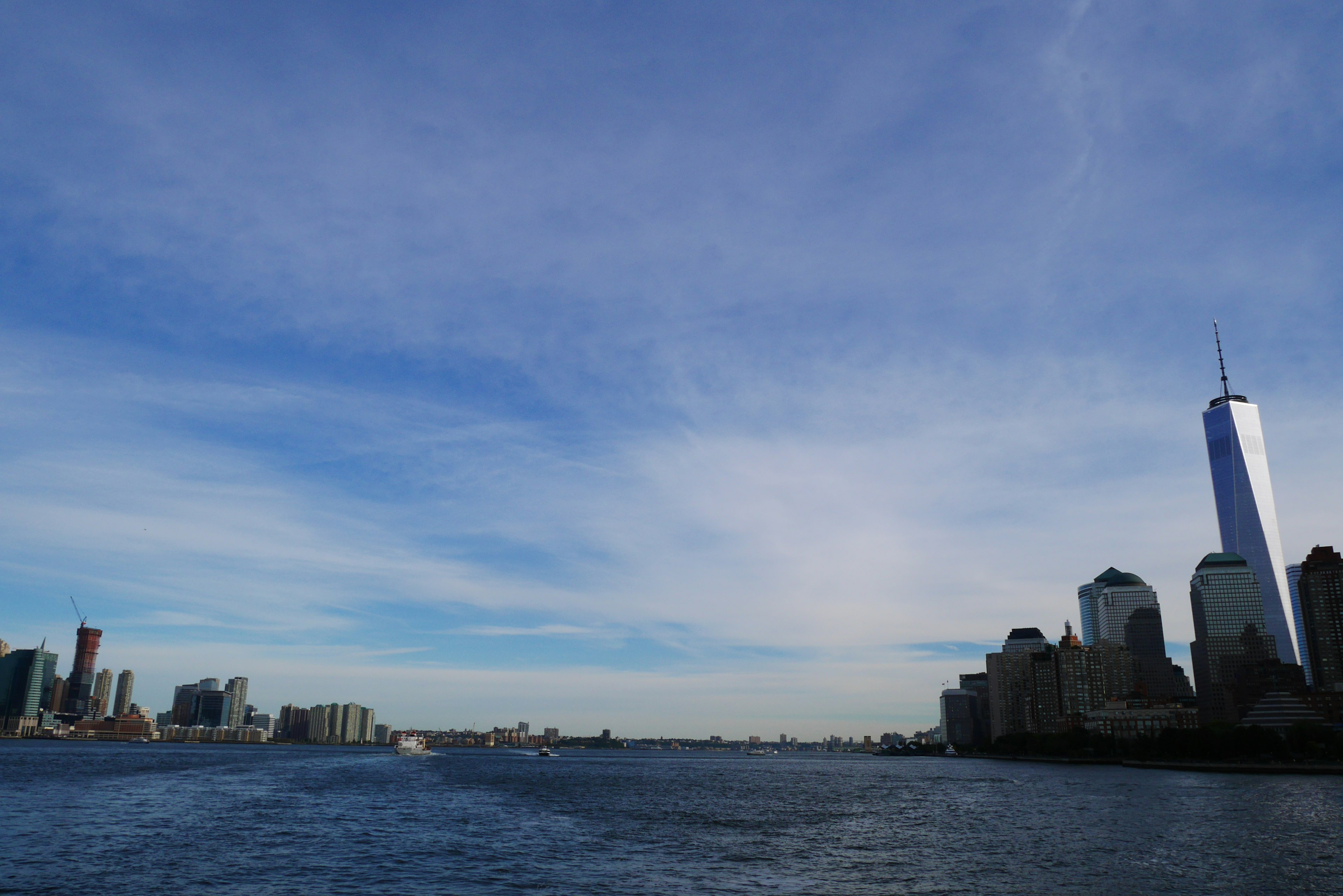 Pemandangan gedung pencakar langit dan langit biru dari tepi air di New York