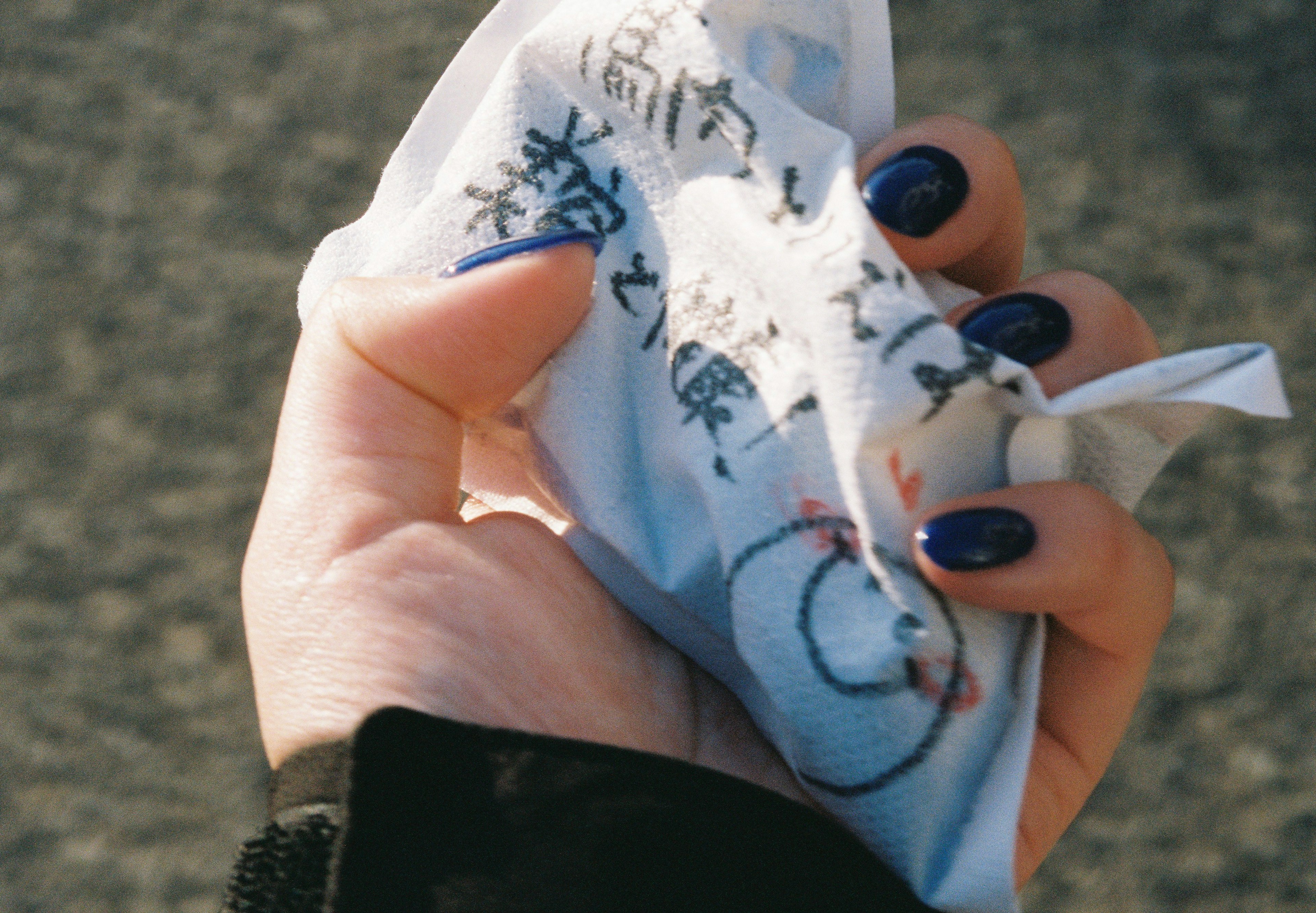 Eine Hand hält einen eingewickelten Gegenstand mit einem niedlichen gestickten Charakter