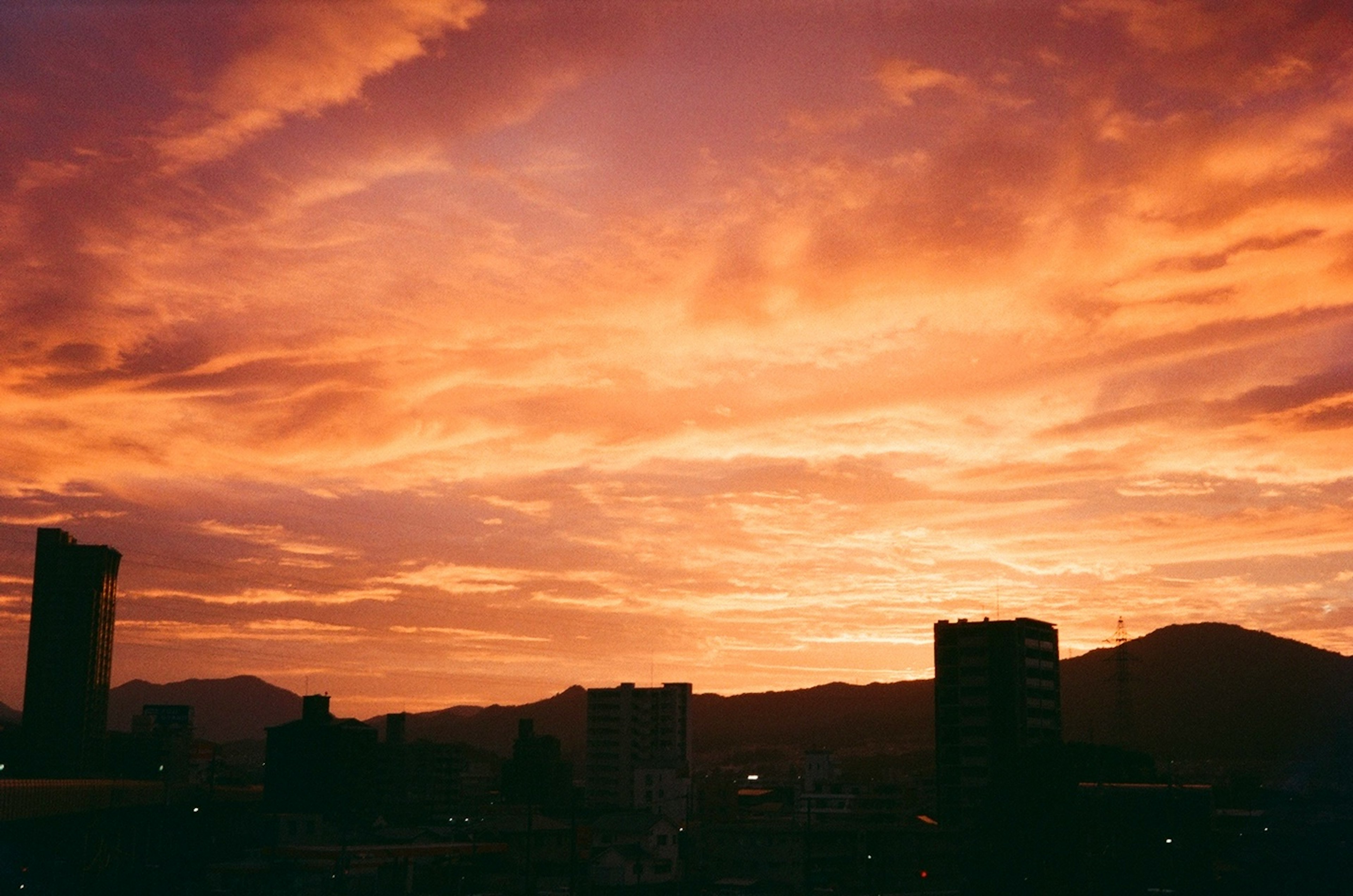 夕焼けの空とシルエットの建物が特徴的な風景