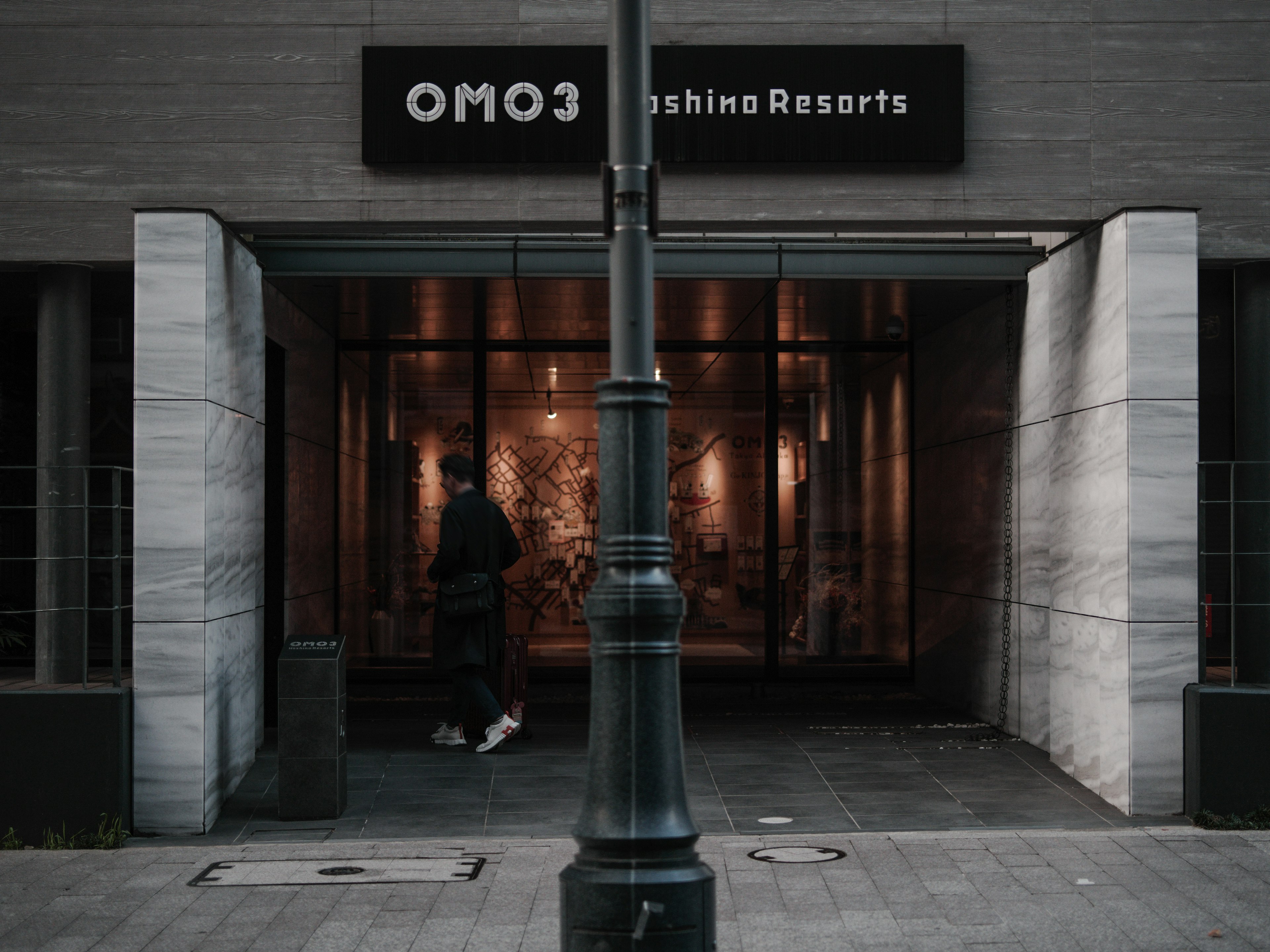 Entrance of OMO3 with a person standing and modern architectural design