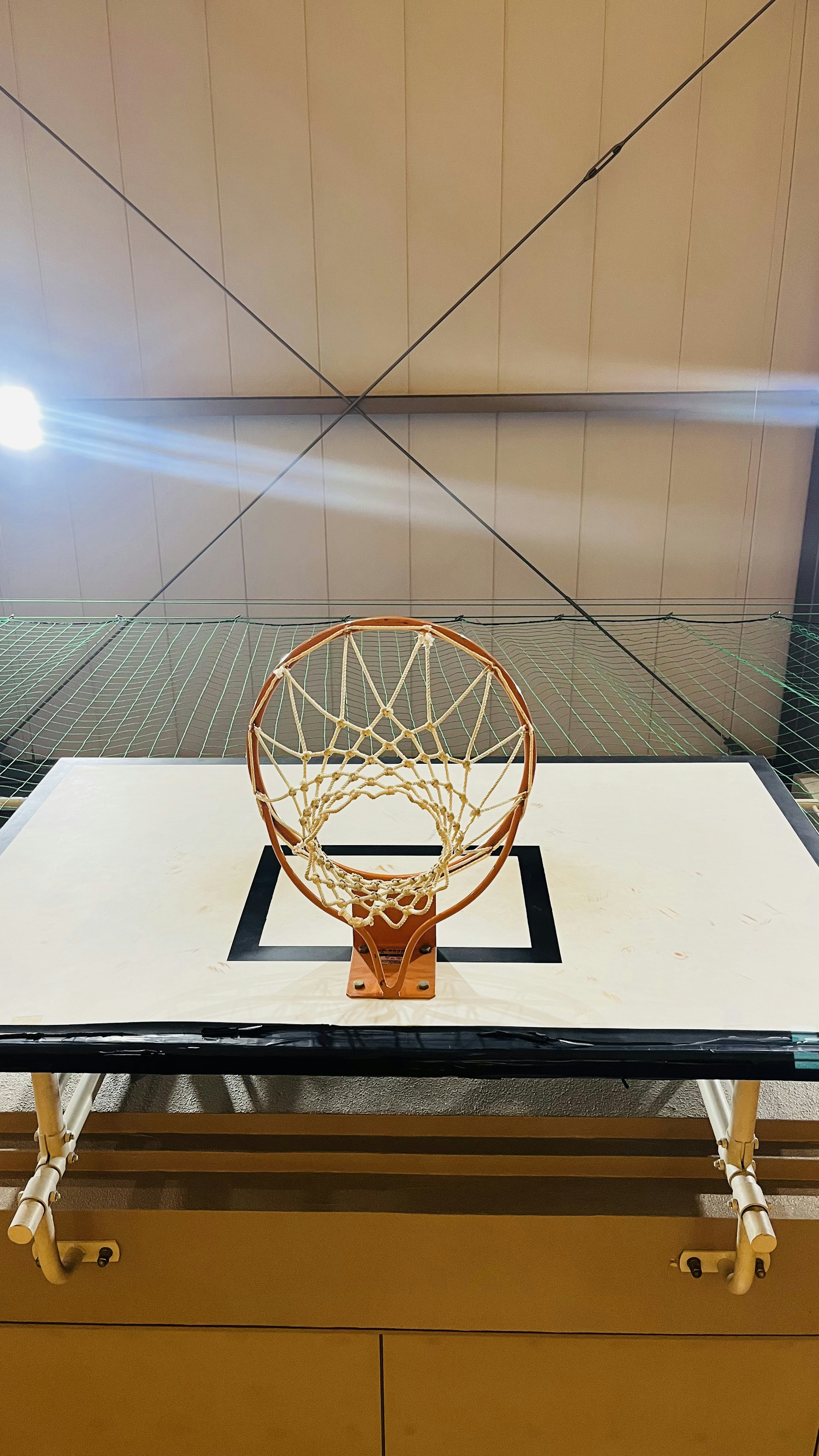 Basketball hoop and net visible in a gymnasium