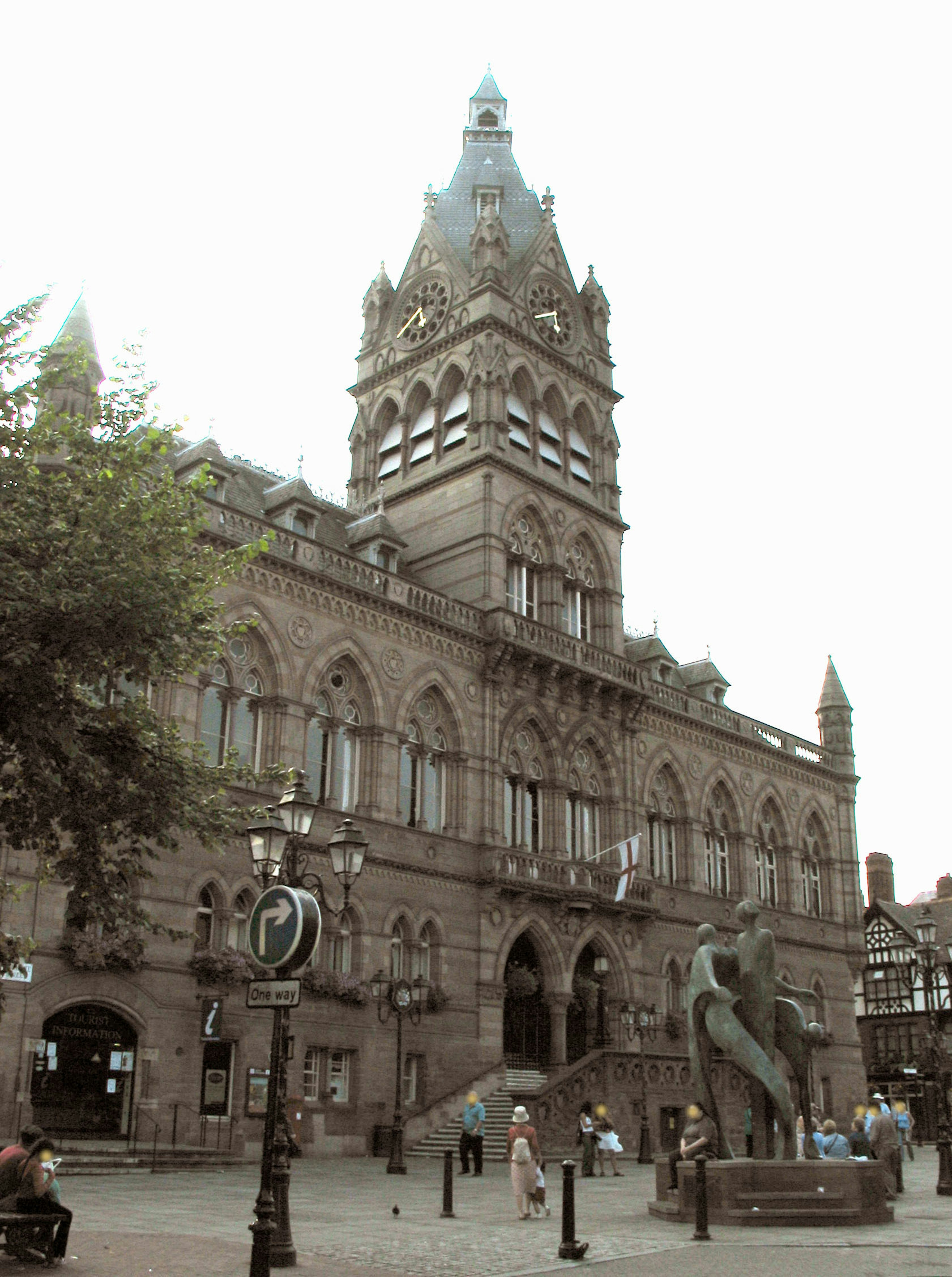 Außenansicht eines historischen Gebäudes mit Turm und Skulptur