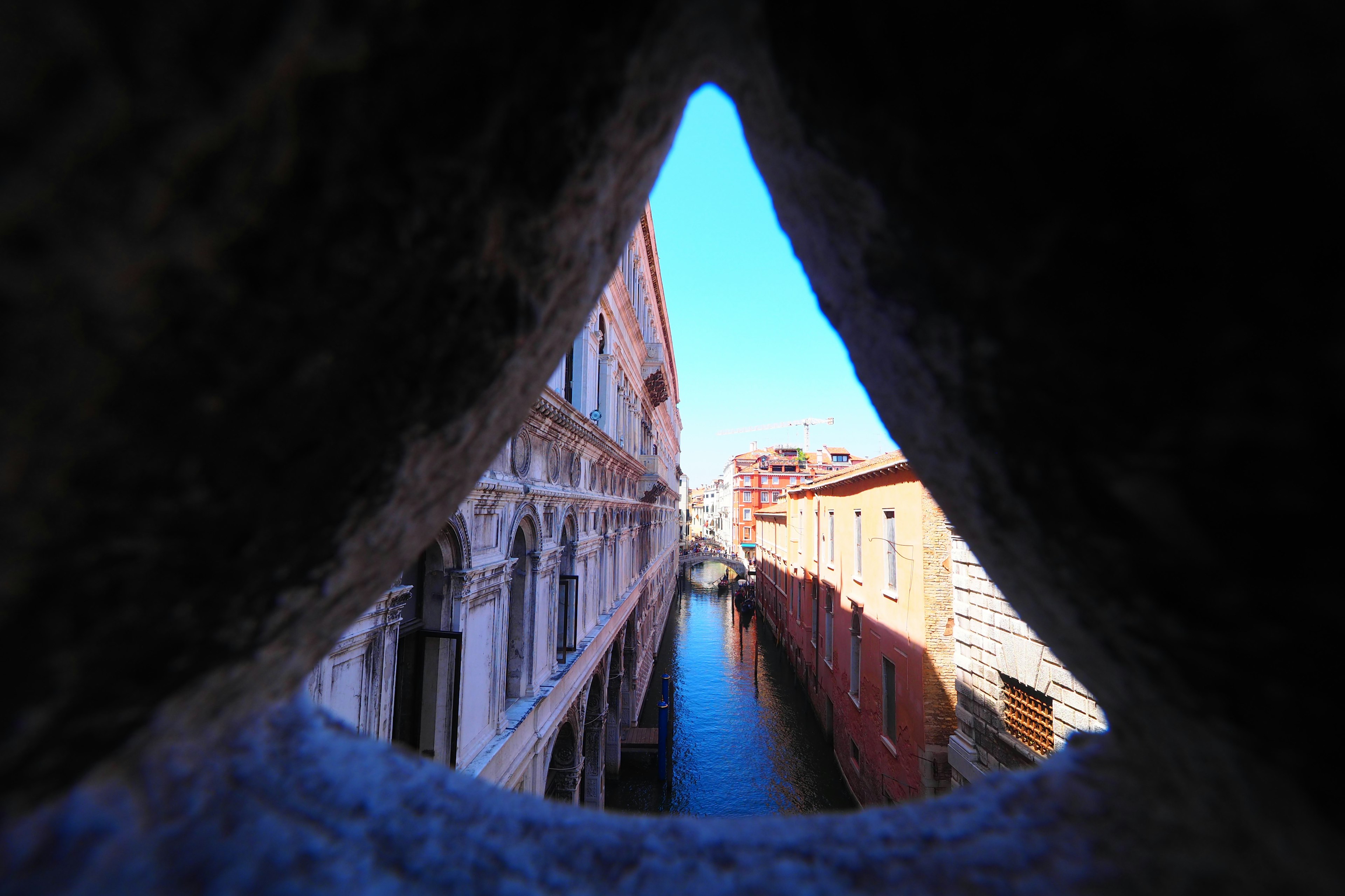 View of a Venetian canal and buildings through a stone arch