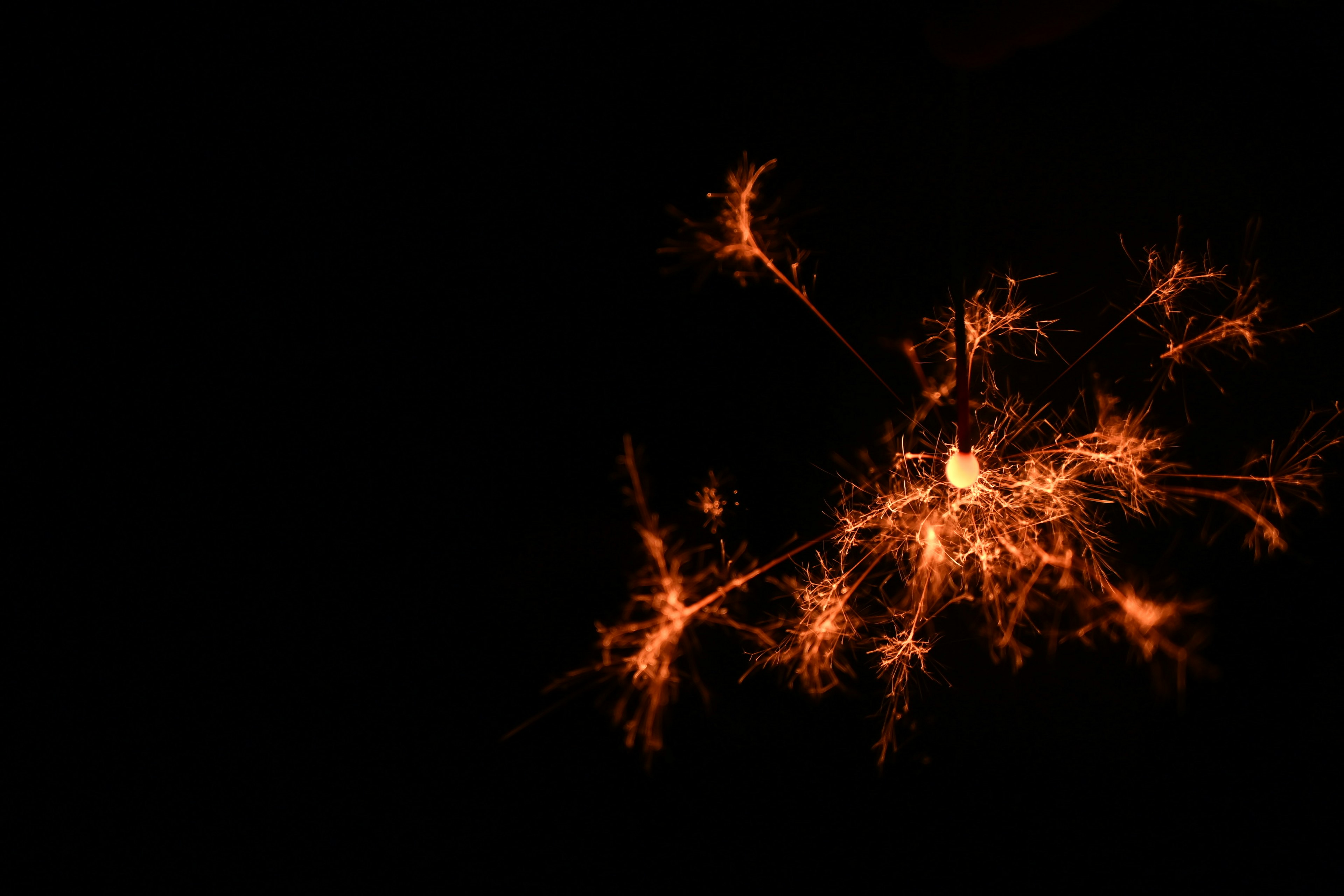 Orange sparks scattering against a dark background