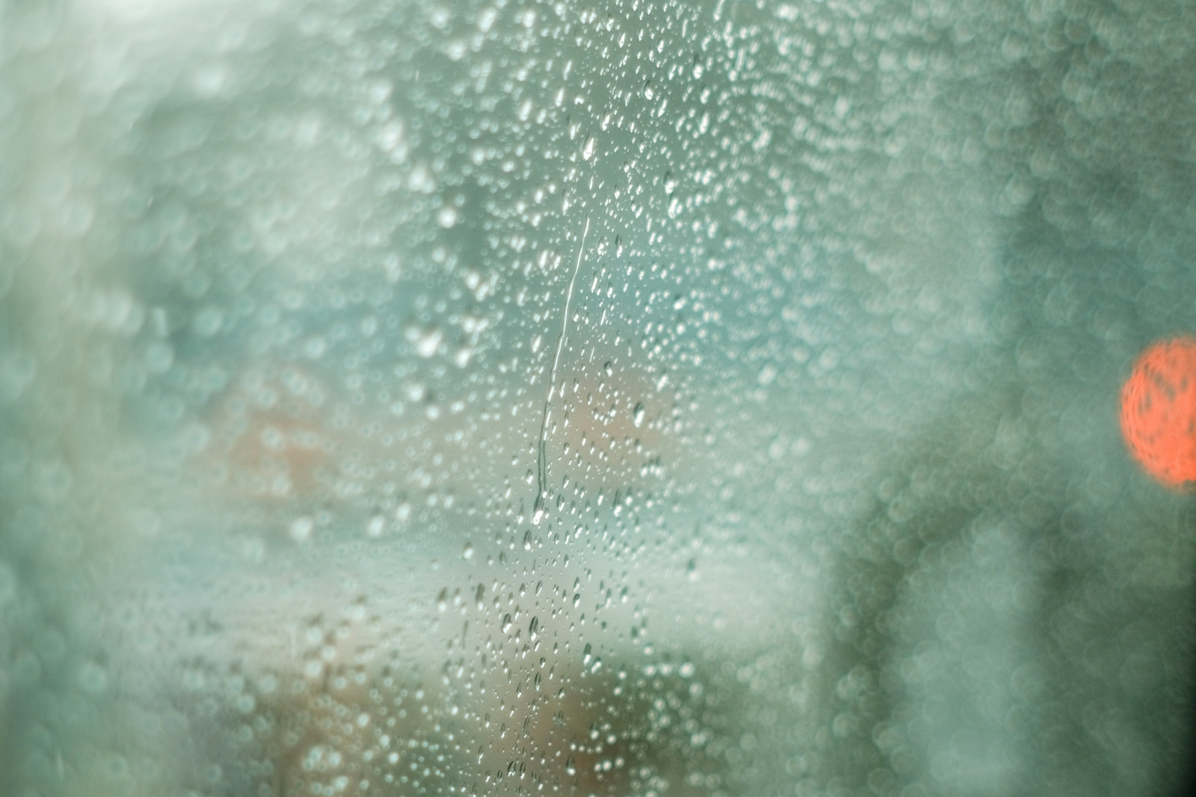 Verschommene Sicht durch ein Fenster mit Regentropfen