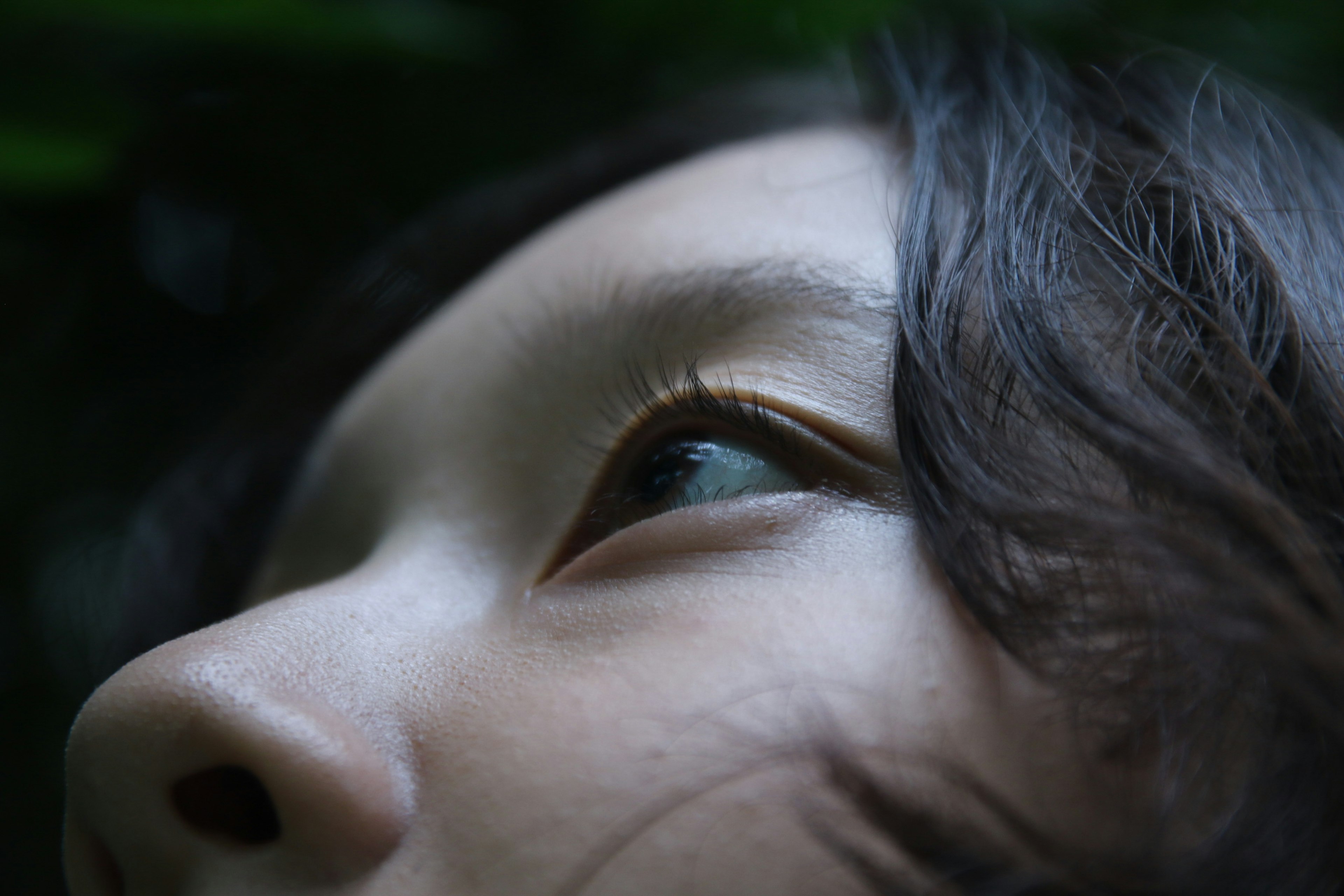 Profil latéral d'une femme regardant vers le haut avec un fond vert